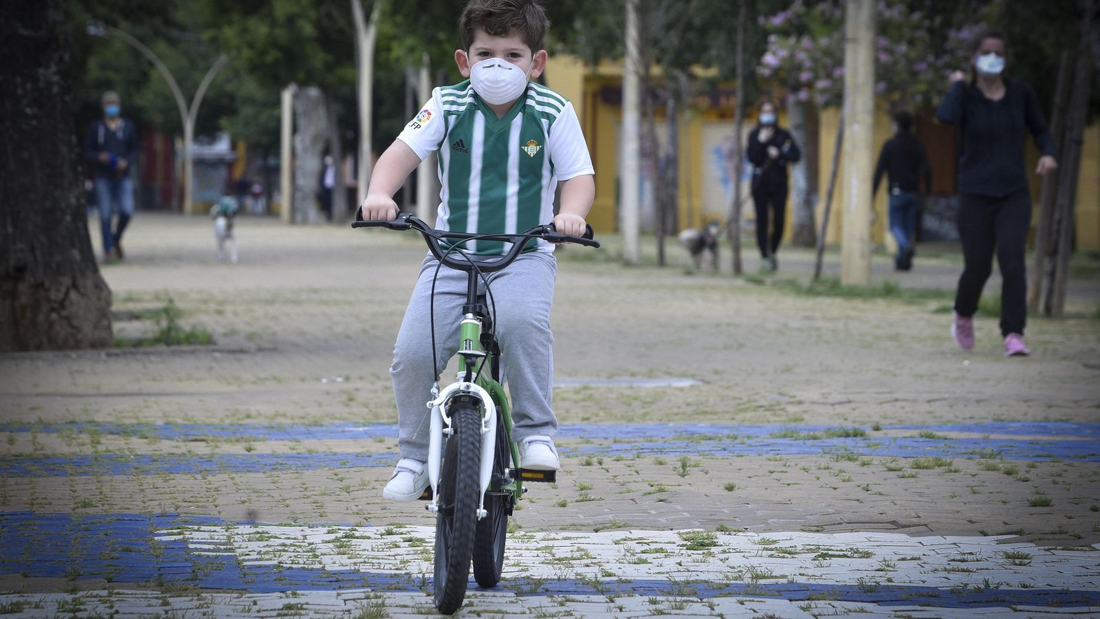 Un niño montado en bicicleta por la Alameda.