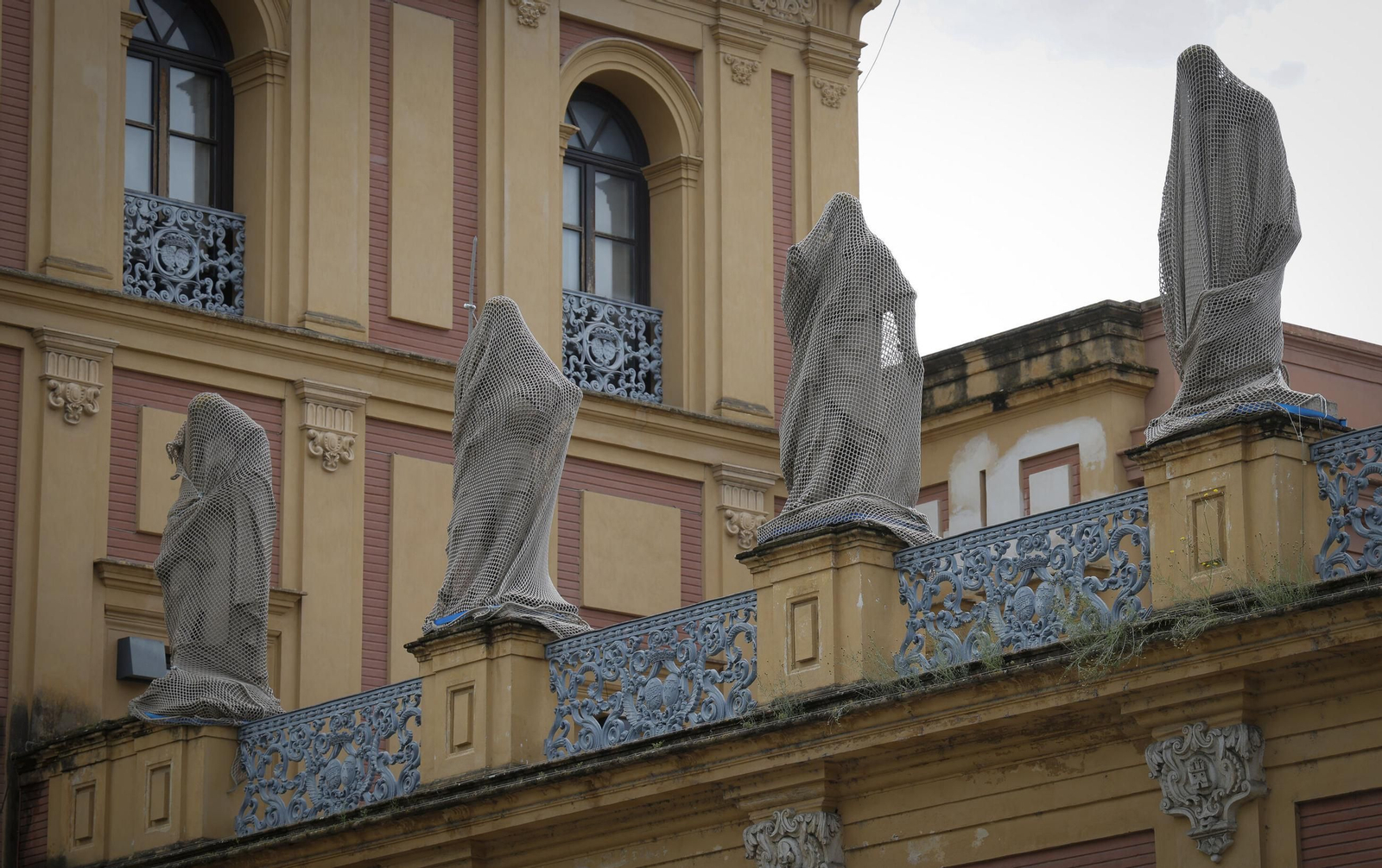 Los Sevillanos Ilustres cubiertos por mallas.