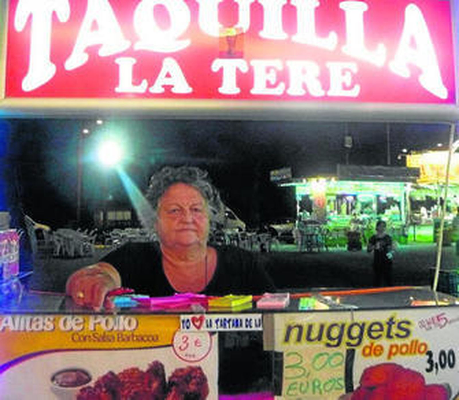 Noche a noche, 'La Tere' atiende a todos sus clientes en la taquilla de su 'tartana'.