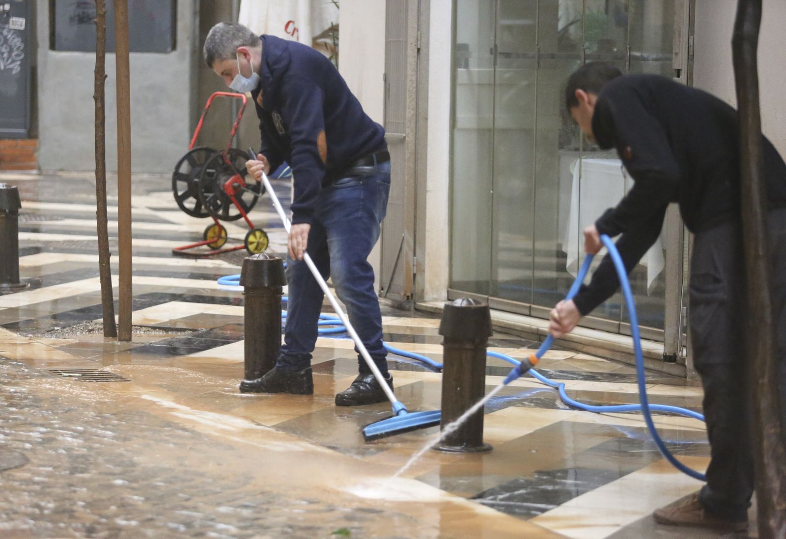 Personas limpiando el barro que deja la calima.