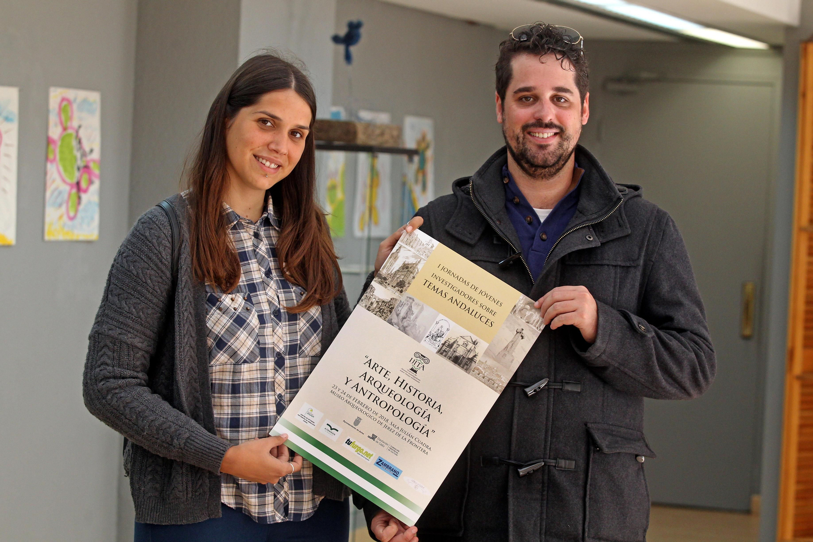 Mercedes Sánchez y Pablo González, miembros del comité organizador, con el cartel de las jornadas.