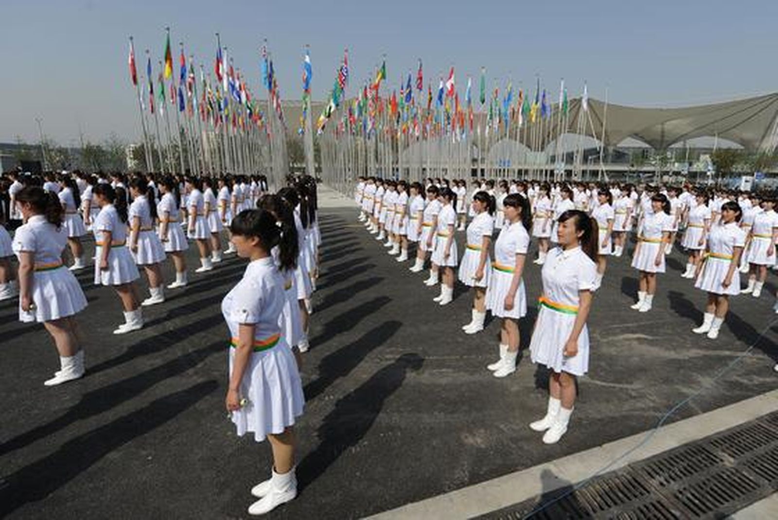 Anfitrionas chinas se reúnen después de levantar las banderas de todos los países participantes en la Expo Mundial de Shanghai 2010.

Foto: AFP Photo