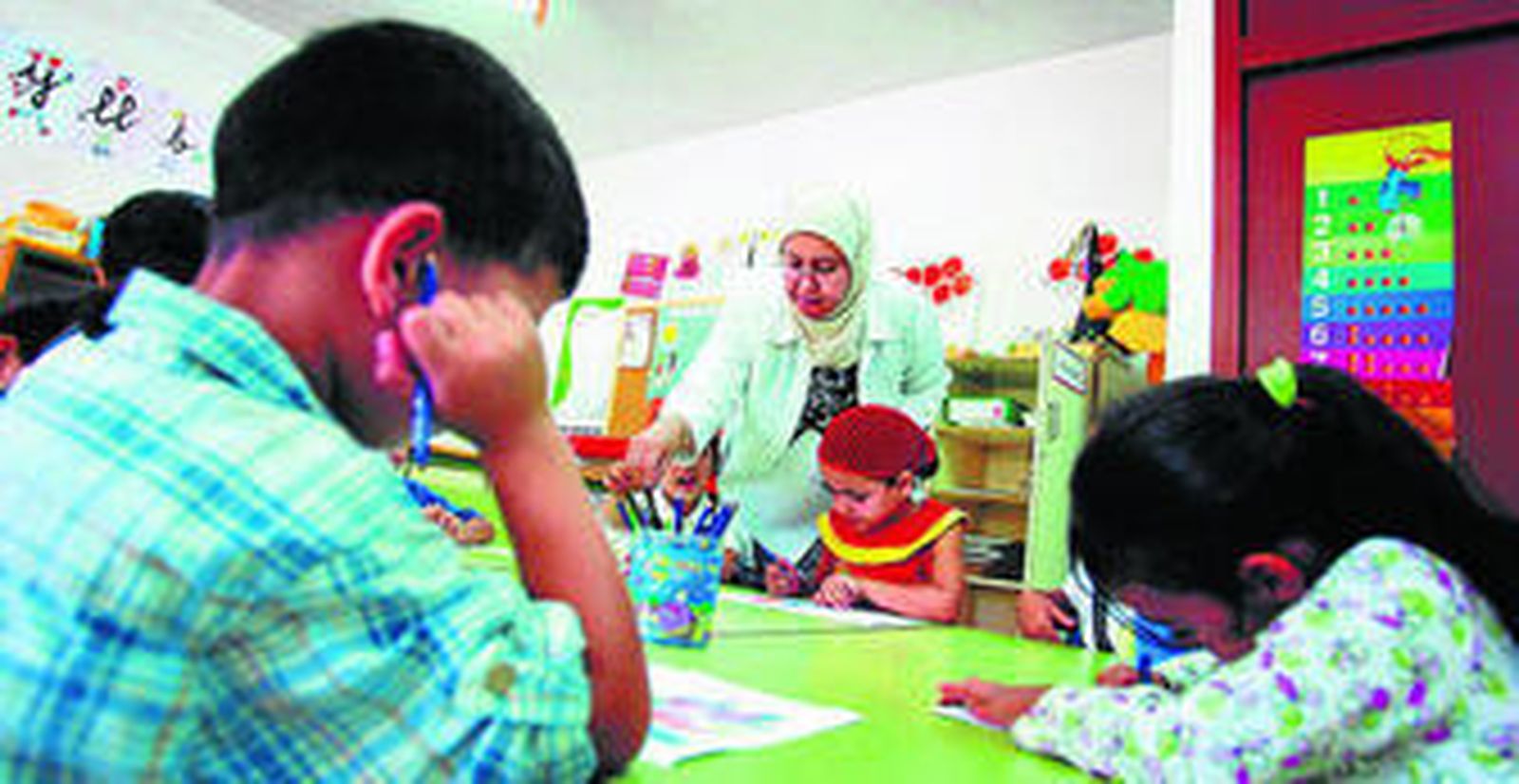Una profesora imparte una clase a alumnos árabes en un centro educativo.