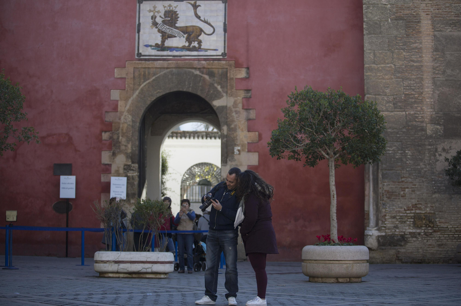 Dos turistas ante la Puerta del León del Real Alcázar, entrada principal al monumento.
