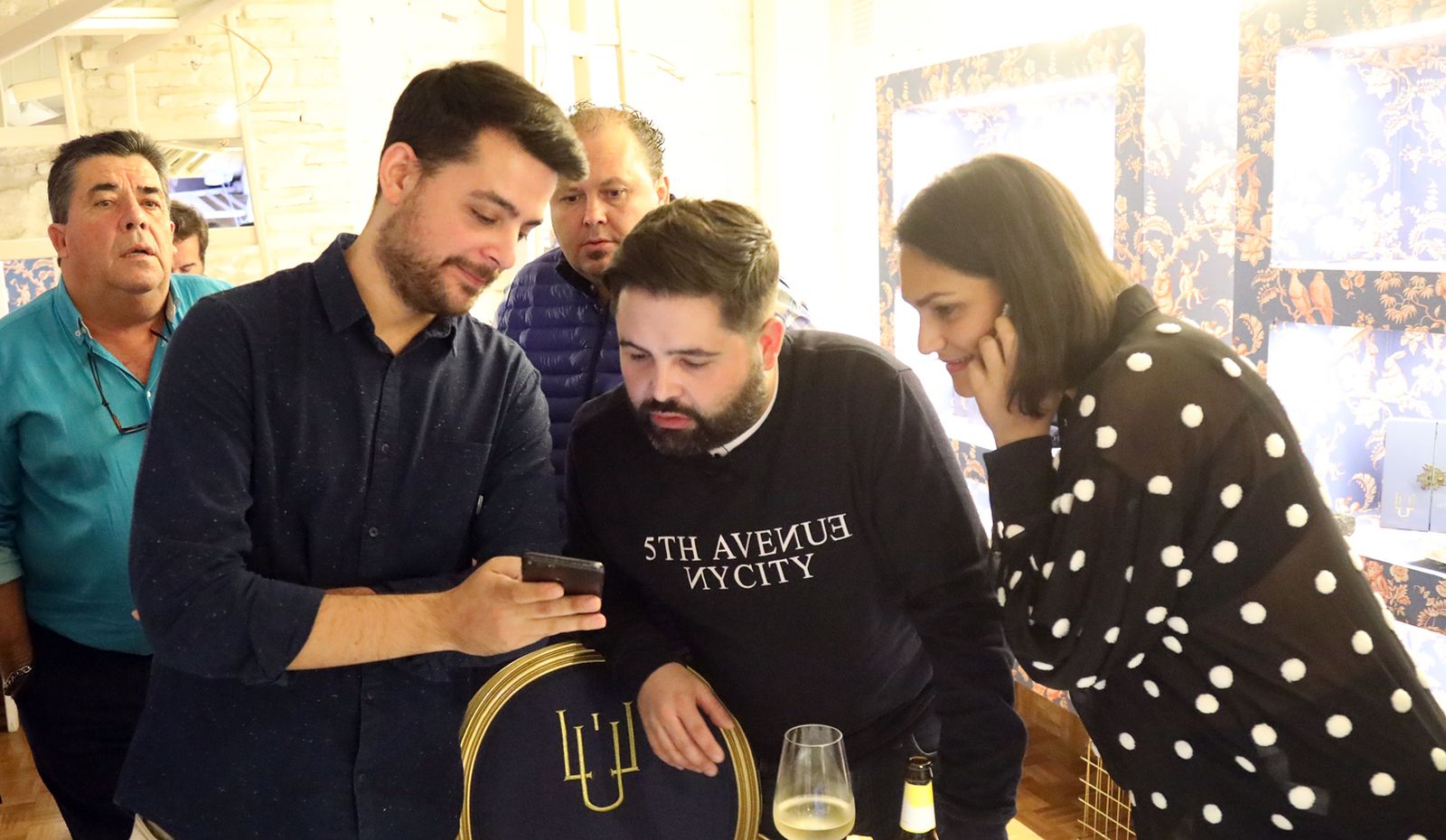Juan Luis Fernández, en el centro, mirando el móvil de un compañero.