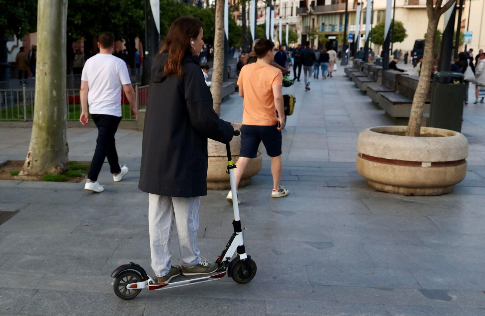 Una usuaria de patinete por una zona peatonal de Sevilla