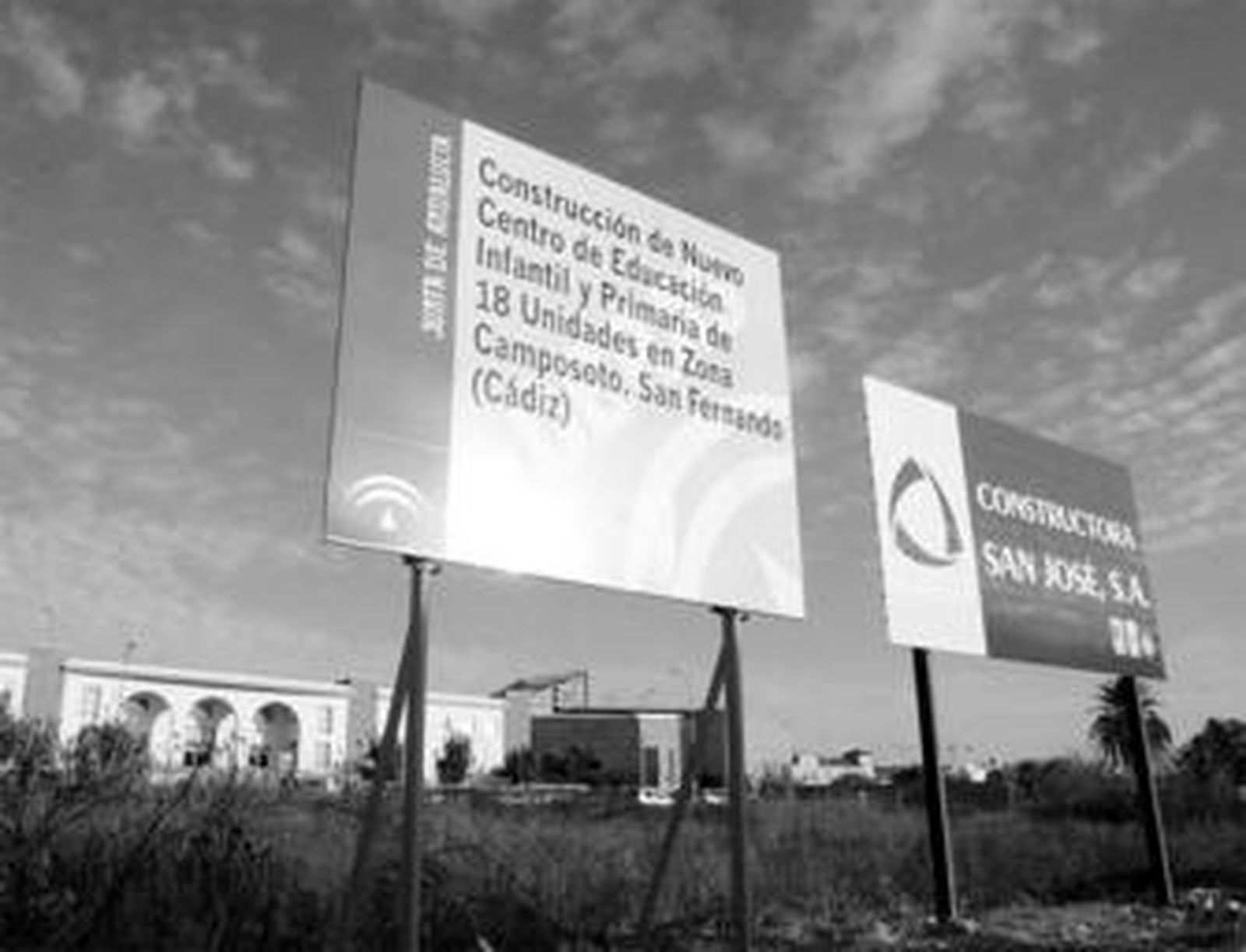 Carteles de la empresa adjudicataria y de la Junta, en los terrenos donde se construirá el nuevo colegio.