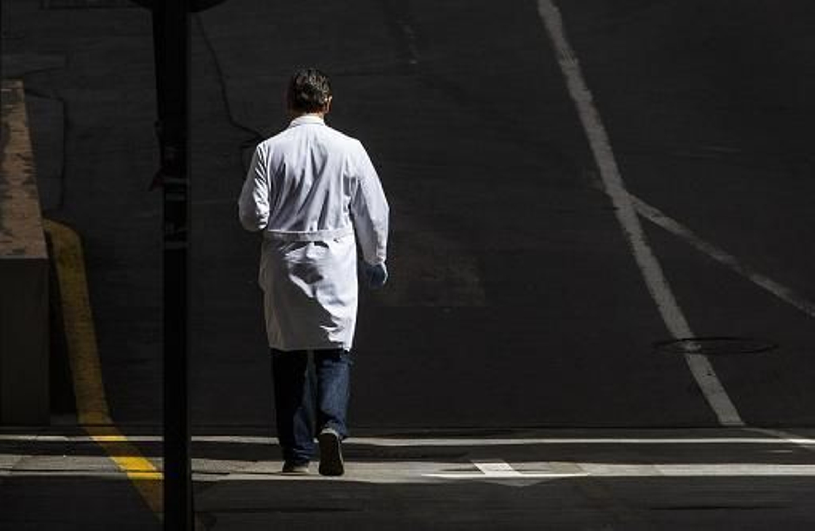 Un médico camina cerca de su centro de trabajo.