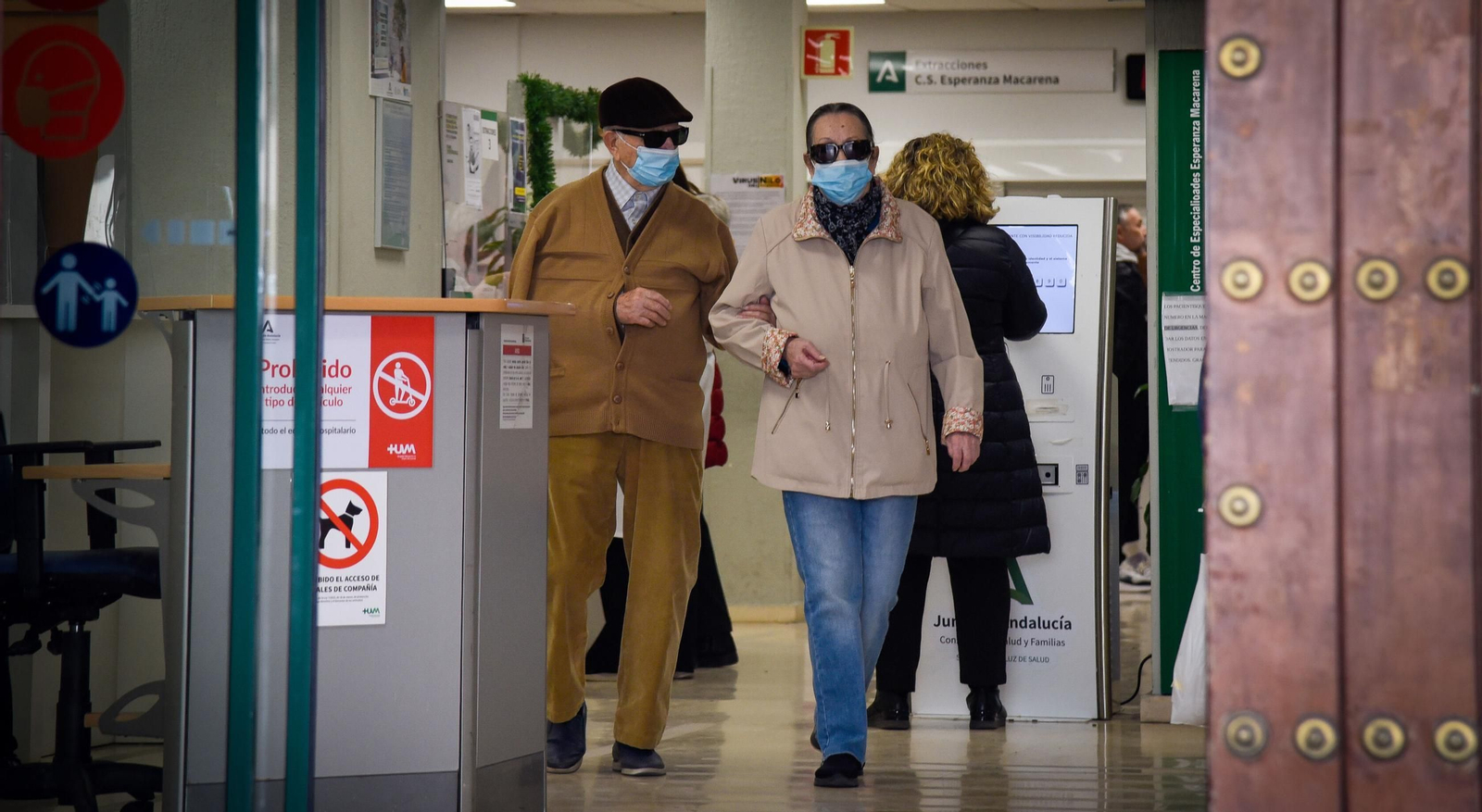 Dos personas con mascarillas en el centro de salud Esperanza Macarena de Sevilla.