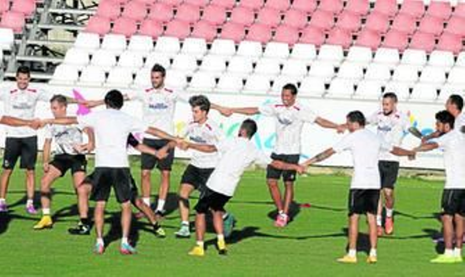 Los futbolistas del Sevilla realizan un juego de activación grupal en una sesión de entrenamienfo.
