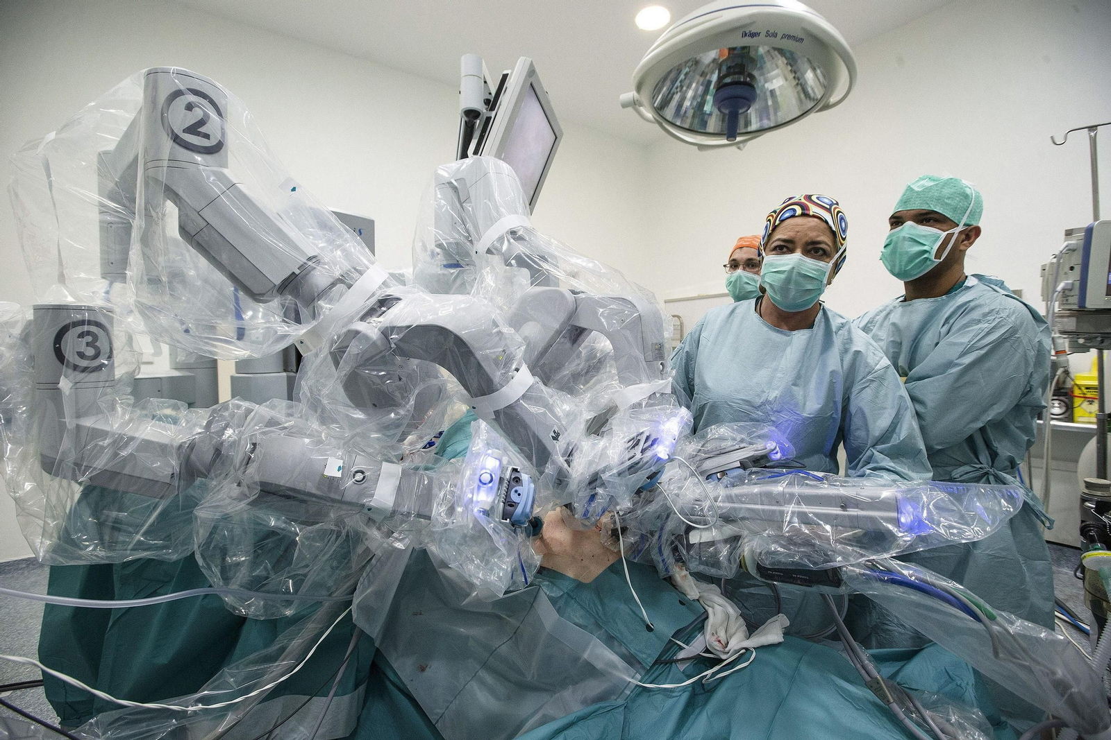 Varios médicos realizan una intervención quirúrgica asistidos por el robot Da Vinci