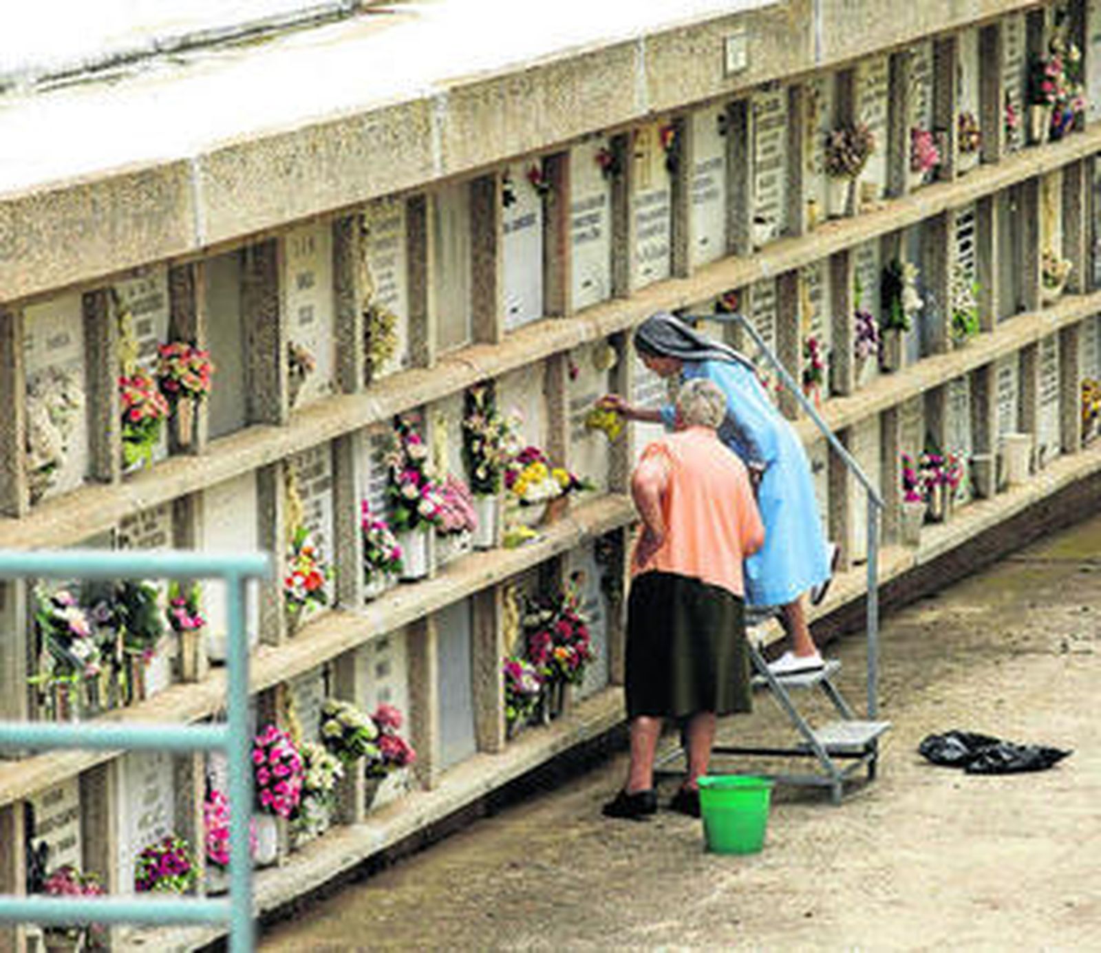Una monja limpia ayer un nicho en el cementerio de San Gabriel.