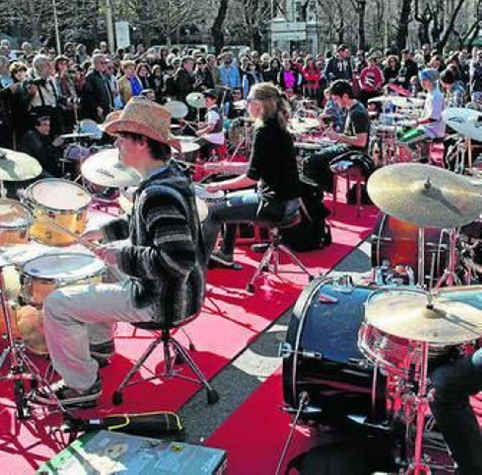 Varias personas tocan la batería frente a la Biblioteca Nacional.