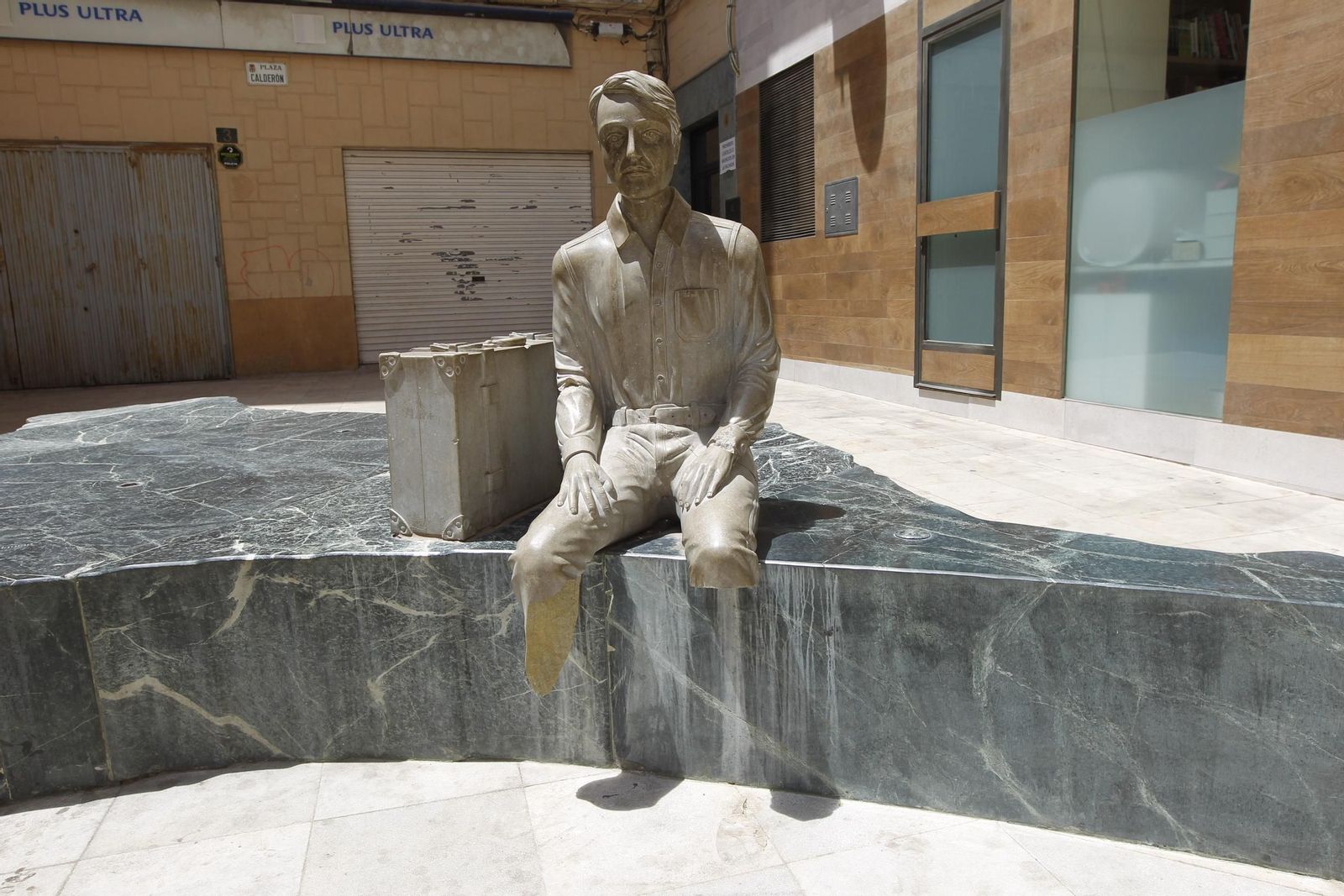 Escultura del inmigrante, con las dos piernas deterioradas.