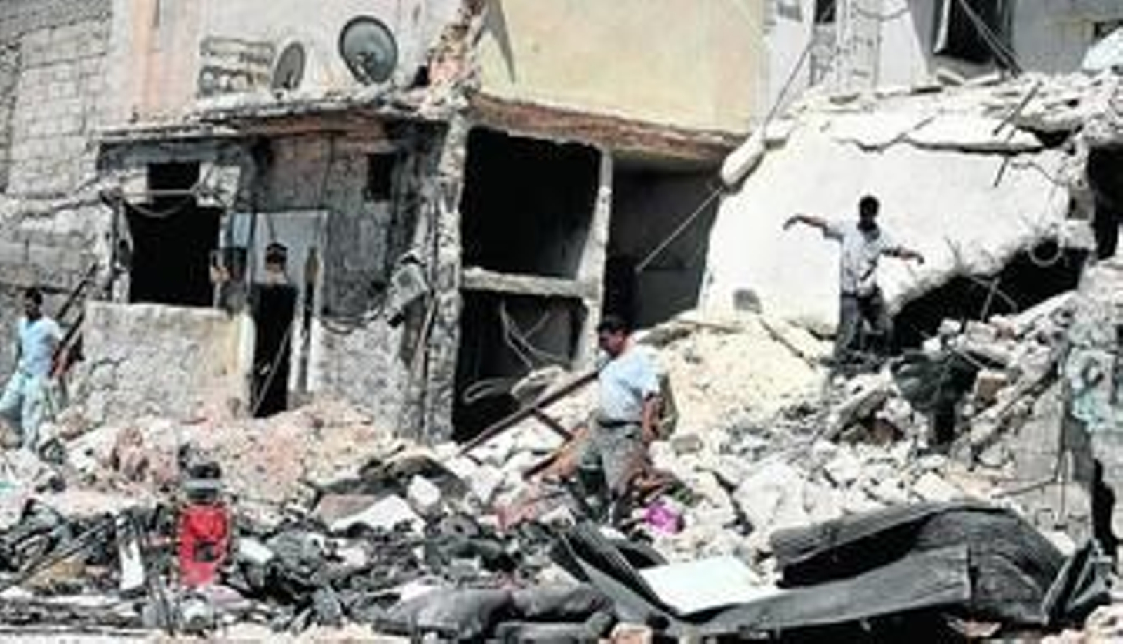 Civiles buscan sus pertenencias entre los restos de sus viviendas tras los bombardeos en Alepo.