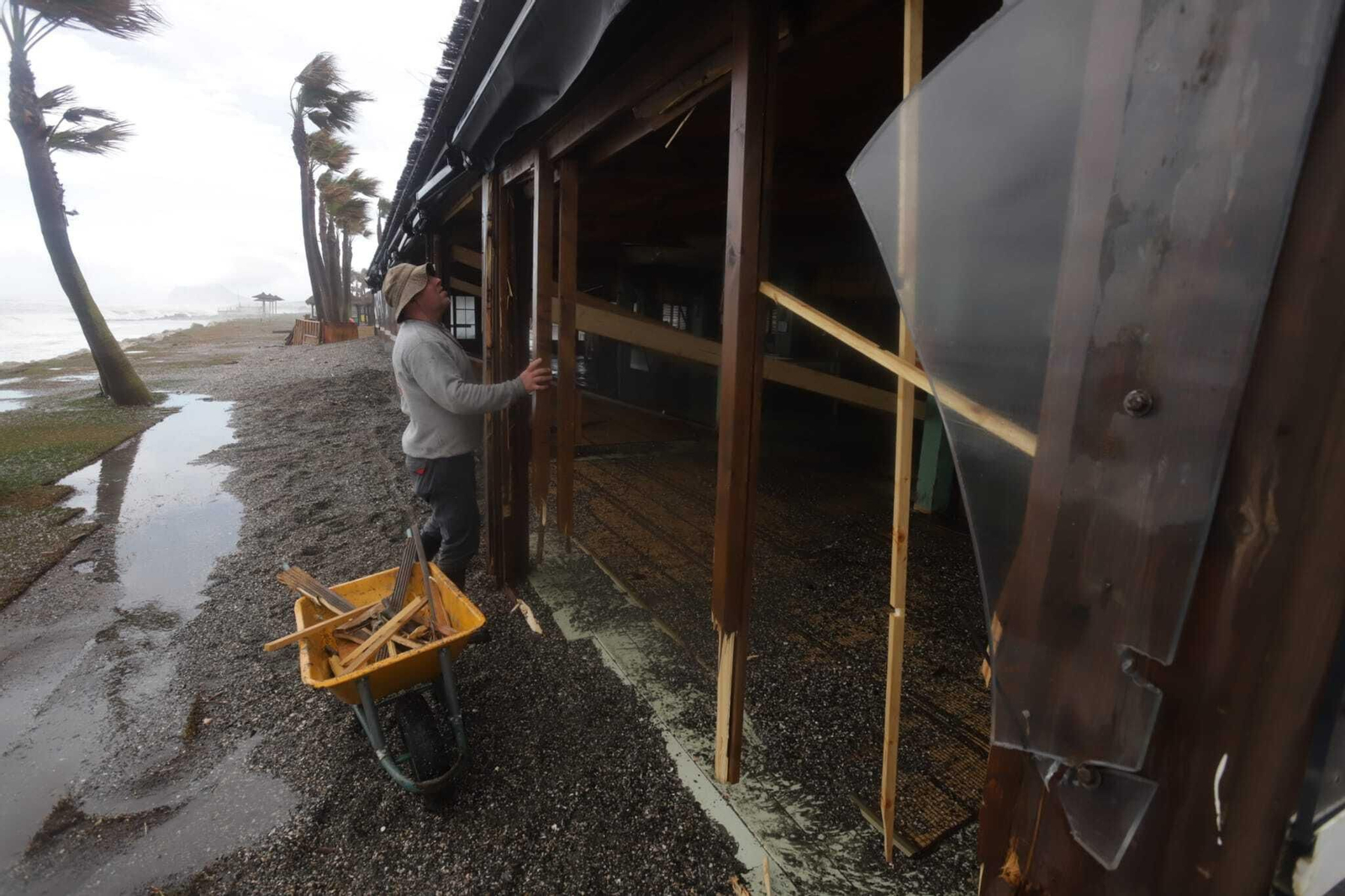 Varias personas limpian los destrozos en un chiringuito de Sotogrande.