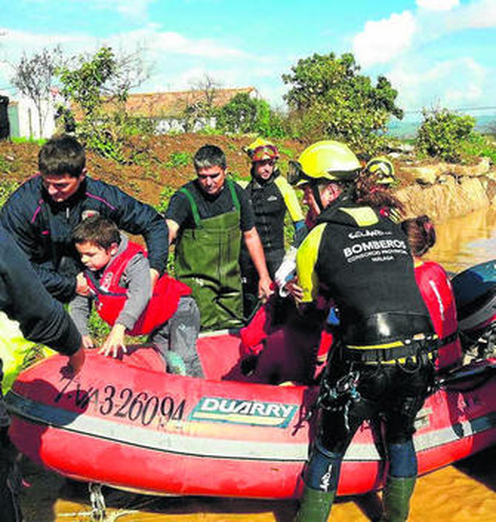 Los bomberos rescatan a una de las familias.