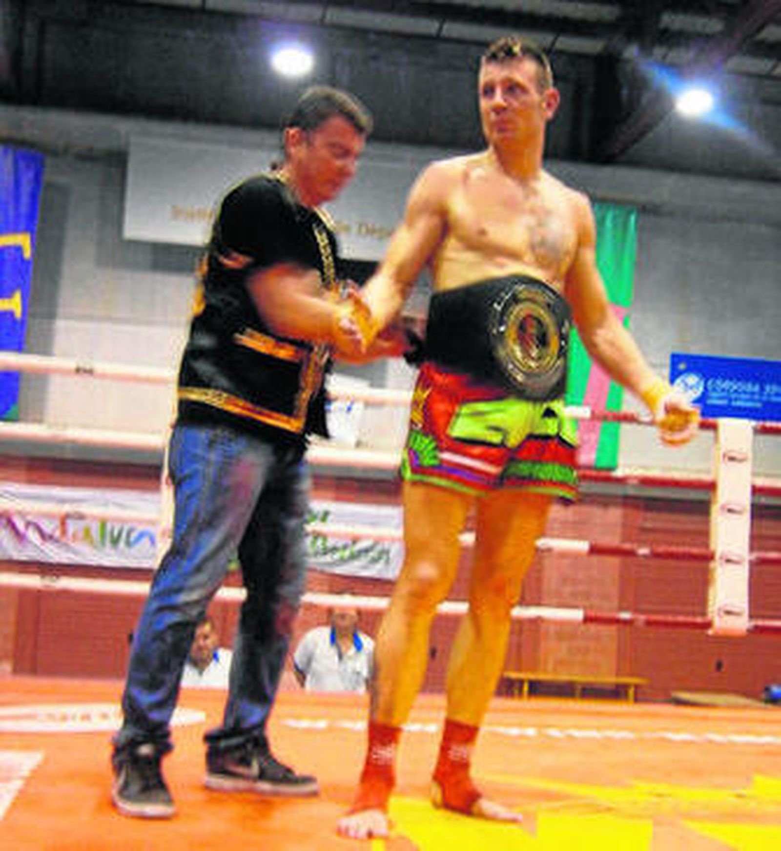 Román Marcial recibe el cinturón que le acredita como campeón nacional.