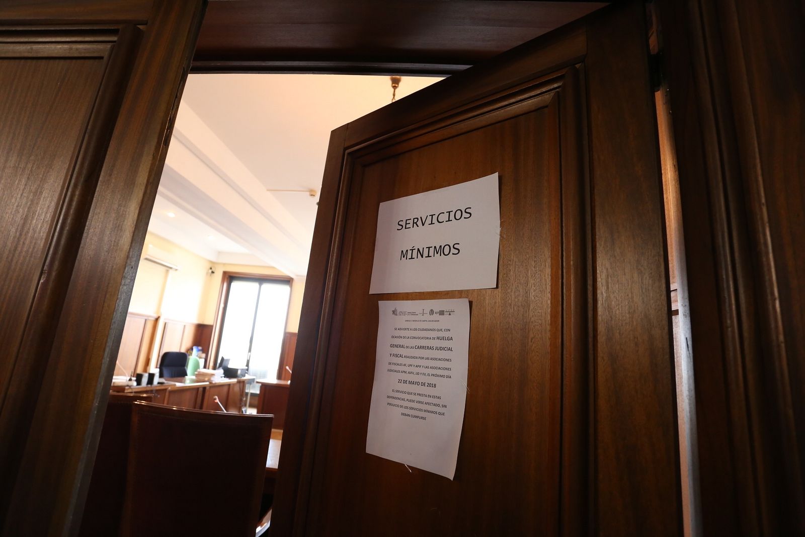Un cartel informa de los servicios mínimos en la puerta de una de las salas de la Audiencia.
