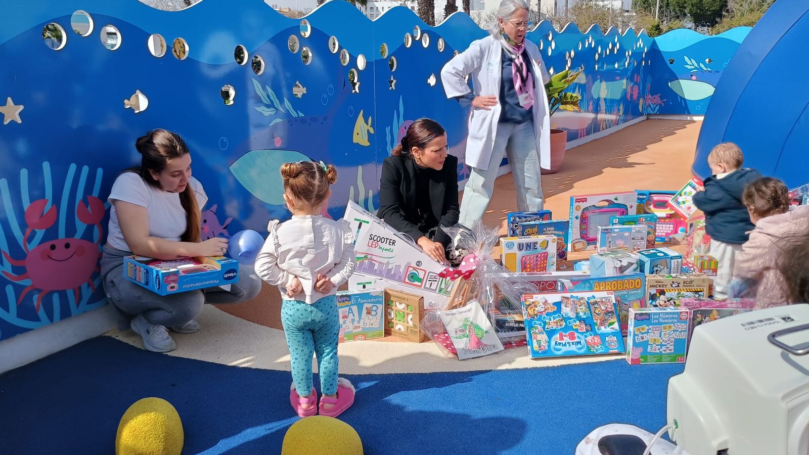 La bailaora María Canea con algunos de los niños hospitalizados que recibieron los regalos para el Patio del Amor.