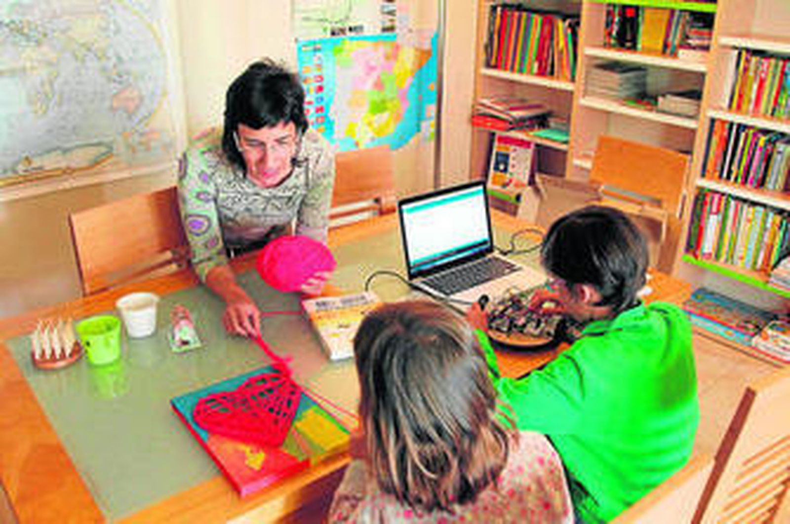 Mamen González trabaja con su hija, mientras su hijo está centrado en un proyecto de robótica.