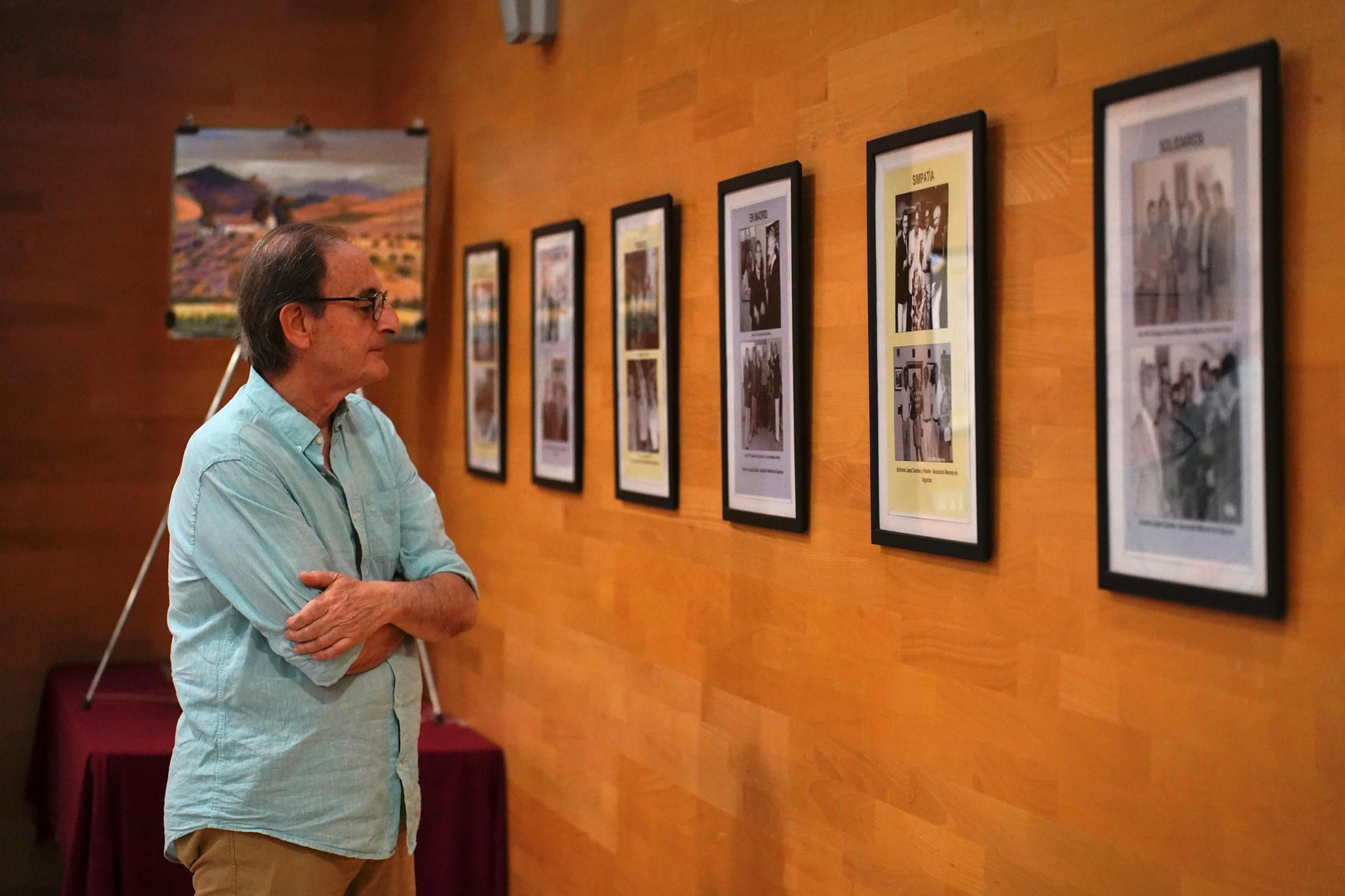 Un hombre observa las fotografías de la exposición de Tría 75.