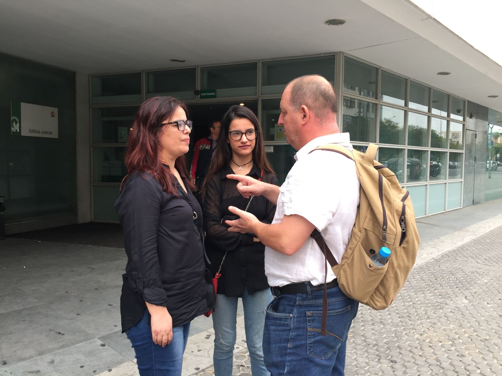 Claudia Domingues (izquierda) y su hija de 23 años conversan con su abogado, Iván Escalera