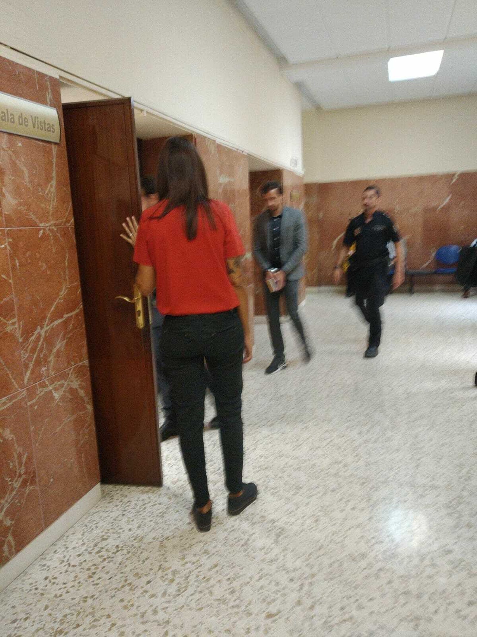 C.T. a punto de entrar en la sala de vistas escoltado por la Policía Nacional.