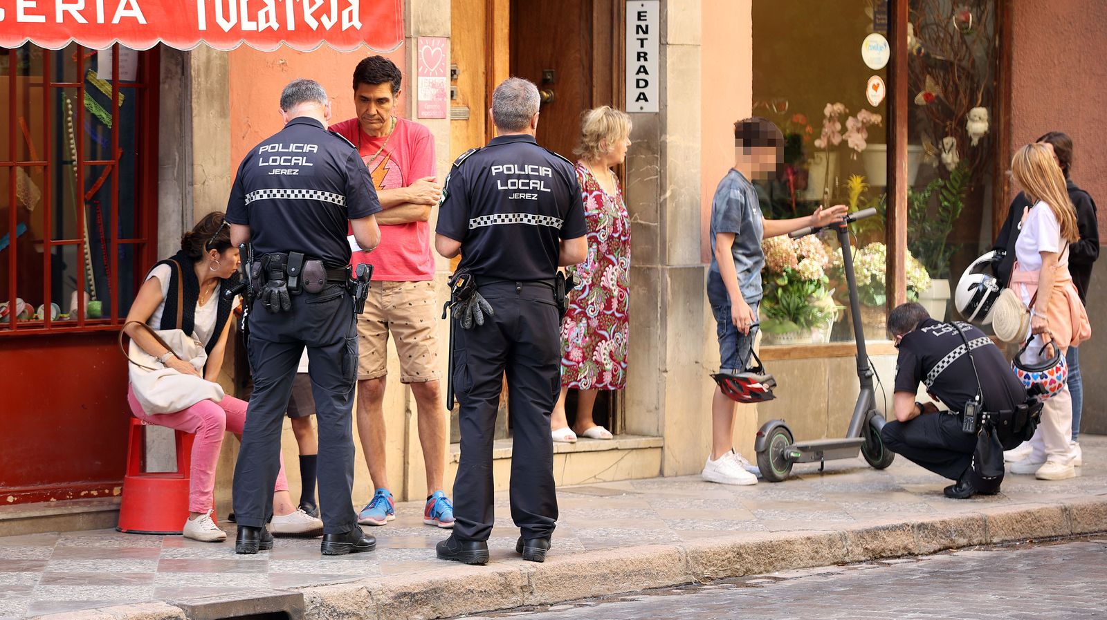 Agentes de la Policía Local, con la mujer atropellada y el menor que montaba el patinete.