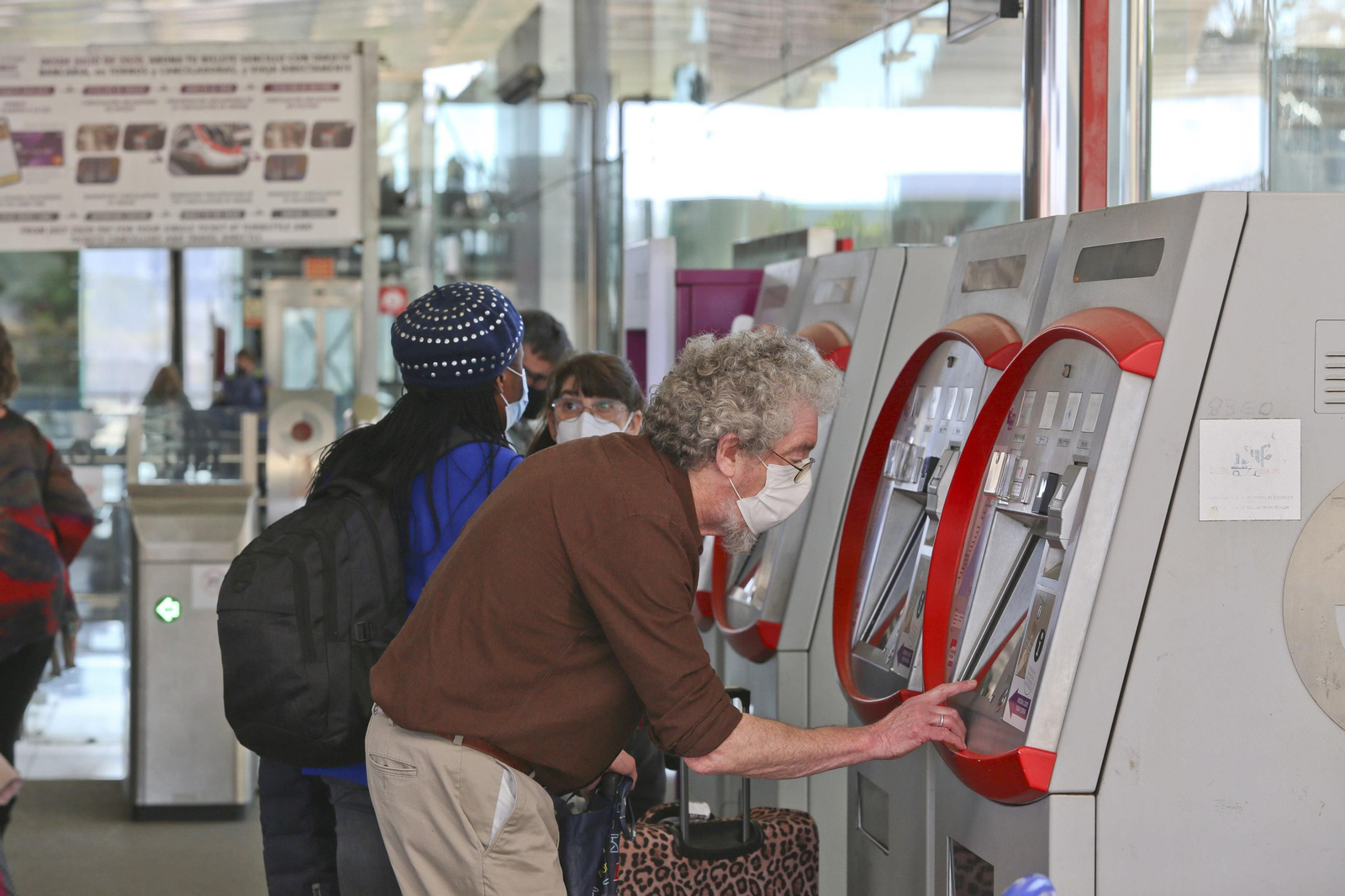 Varios pasajeros compran el billete en las máquinas del Cercanías en Málaga.