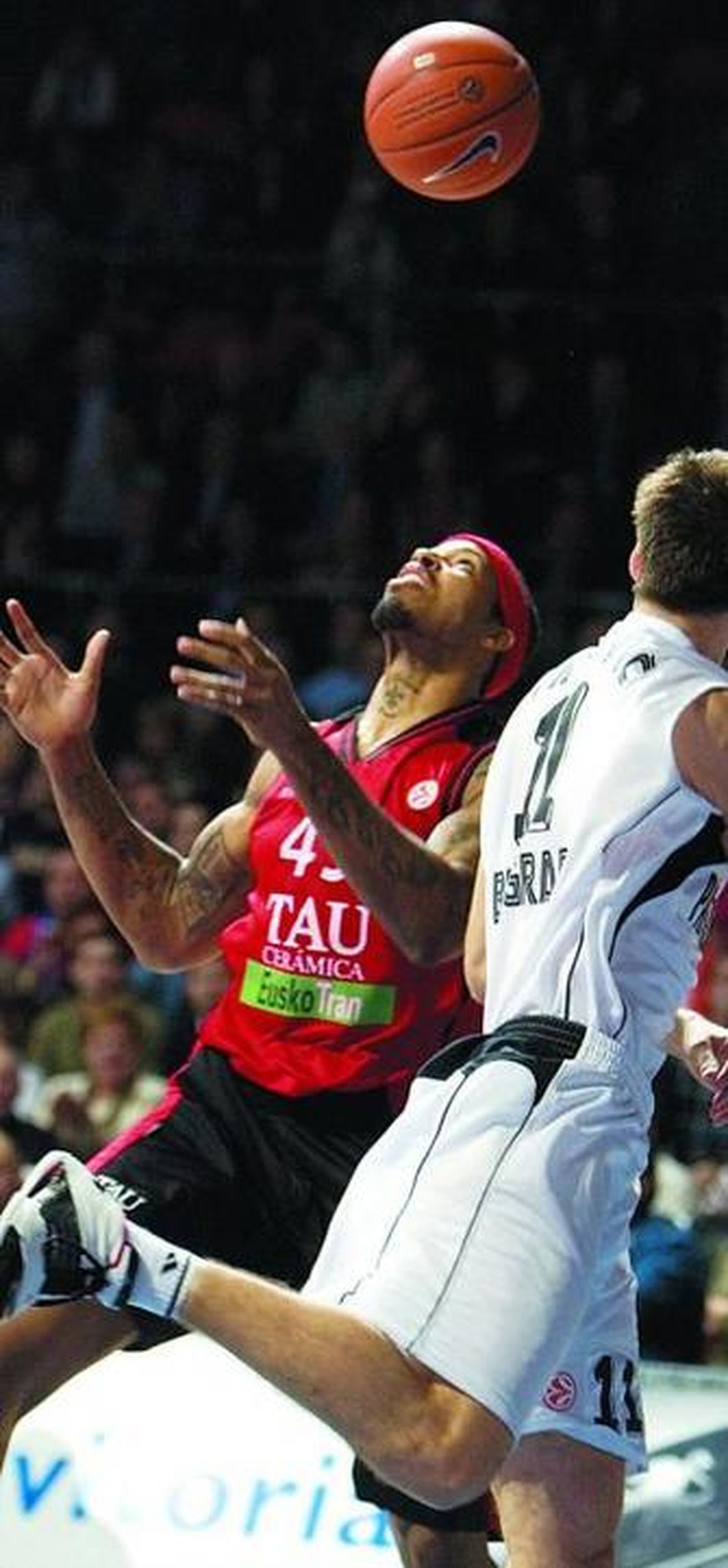 McDonald y Tripkovic miran el balón en busca de un rebote.