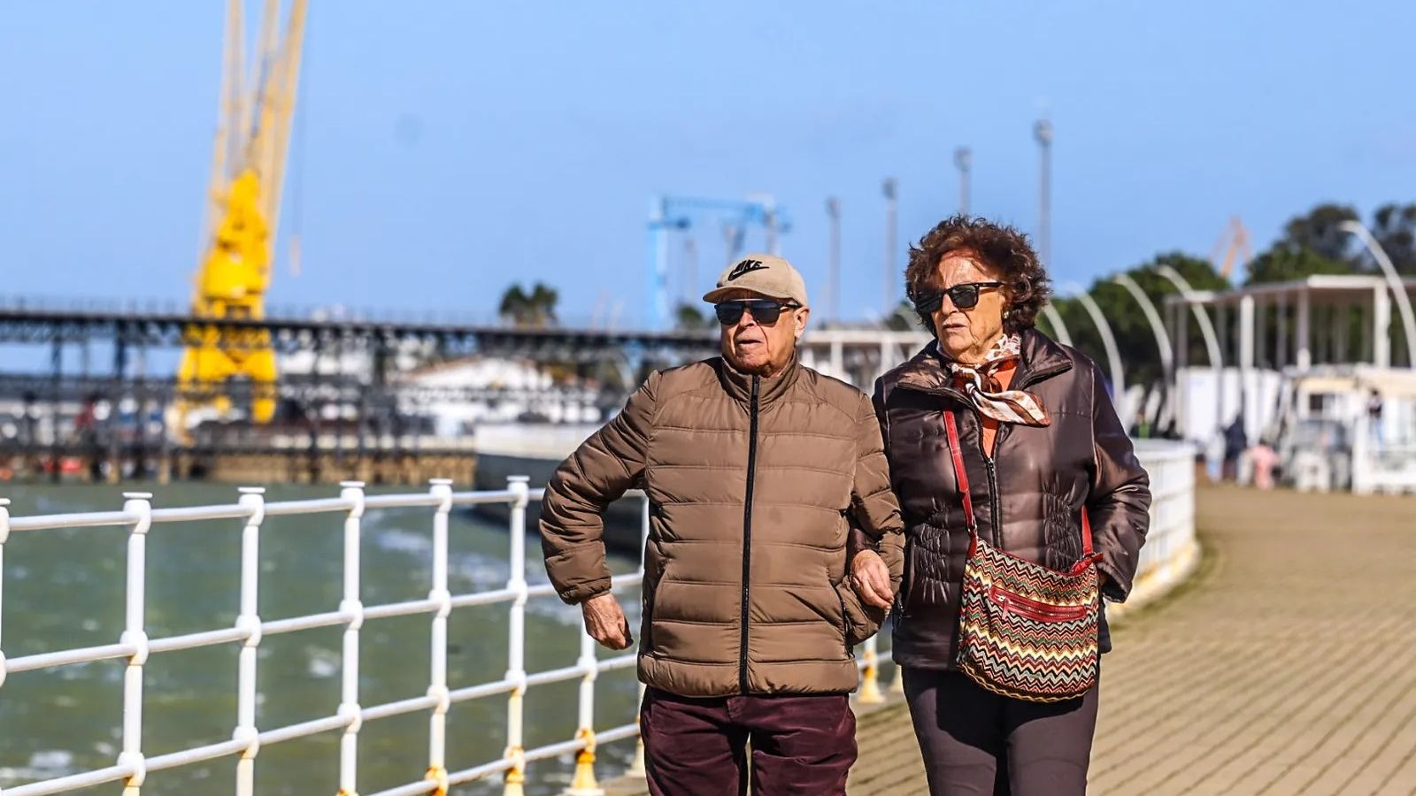Dos personas pasean aprovechando un día de sol en Huelva.