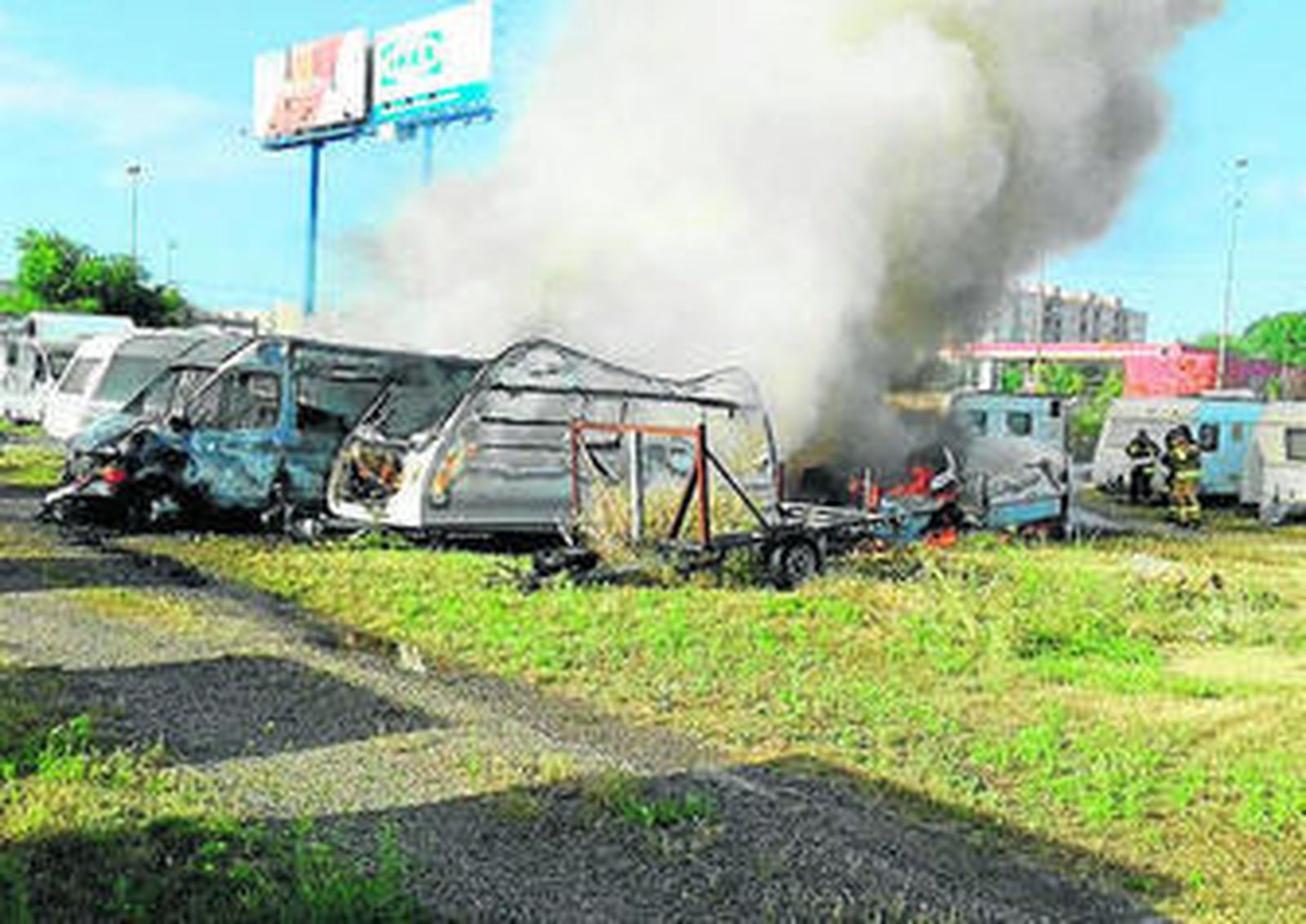 Los Bomberos sofocan el fuego en uno de los vehículos.