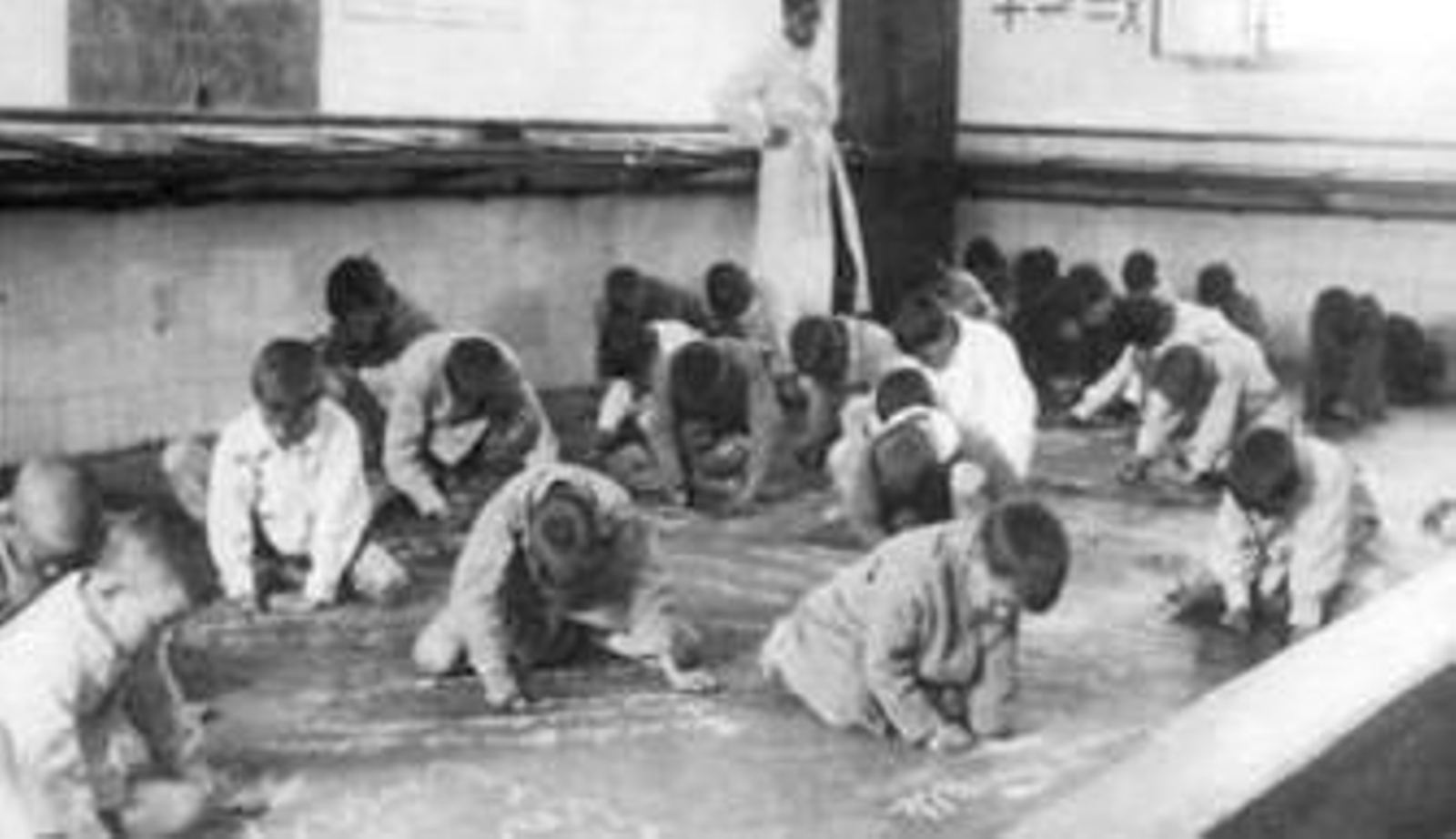 Alumnos escribiendo en el suelo, uno de los métodos pedagógicos