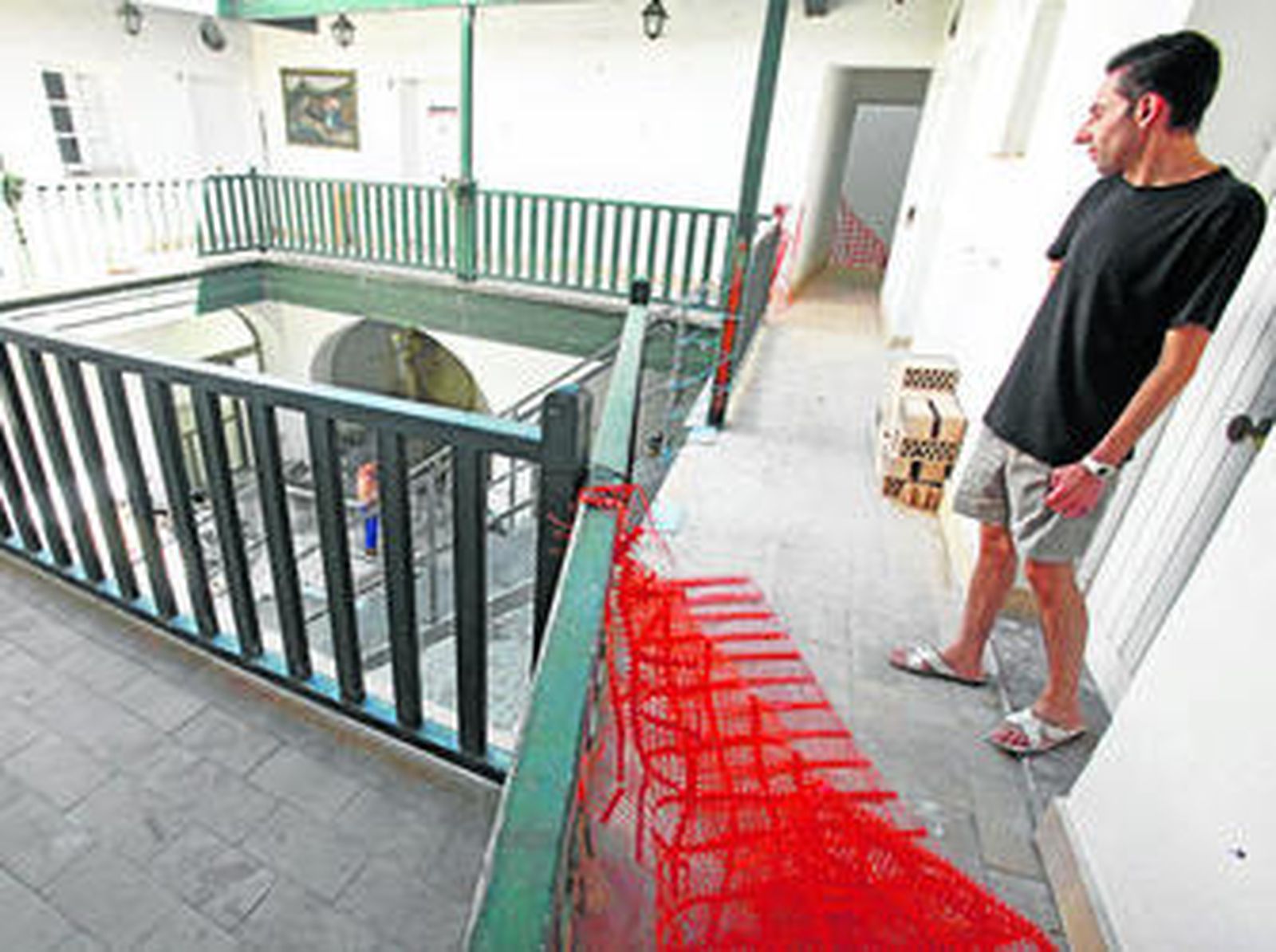 Antonio observa el puente metálico que sustituye a la escalera y por el que deben acceder a su vivienda.