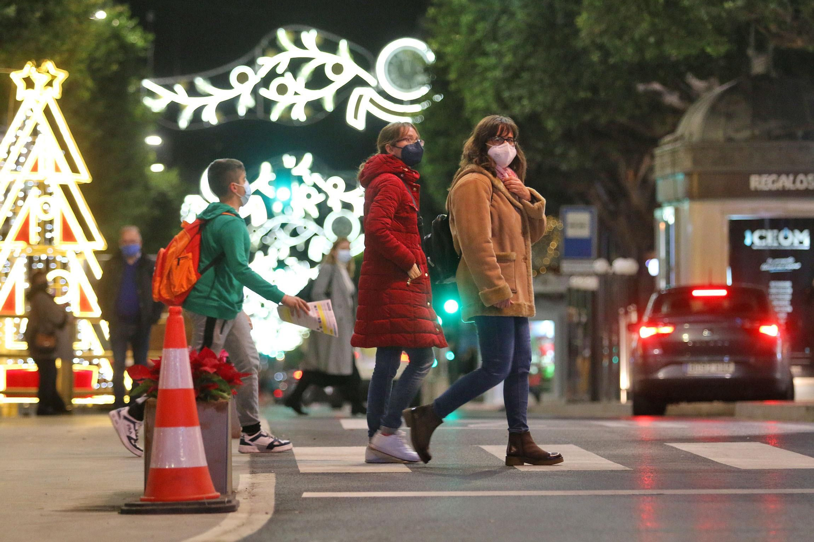 Varias personas pasean con sus mascarillas.