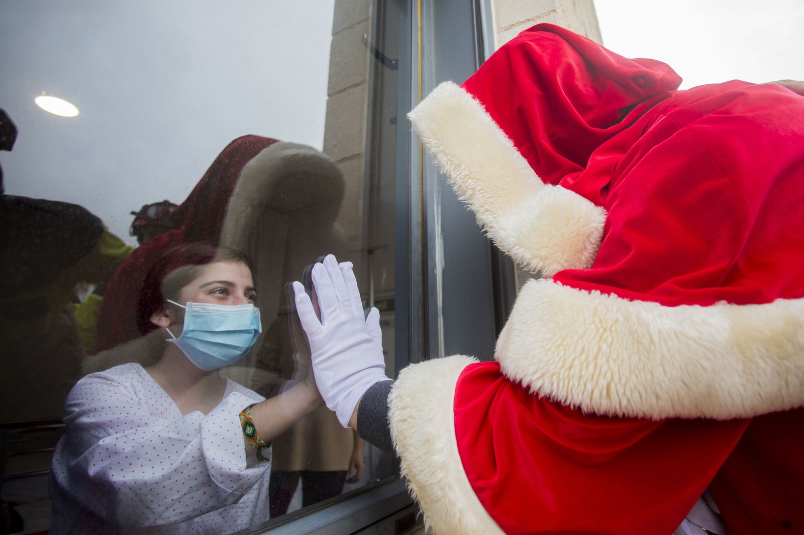 Papá Noel saluda a uno de los niños ingresados en la Unidad de Pediatría del hospital onubense