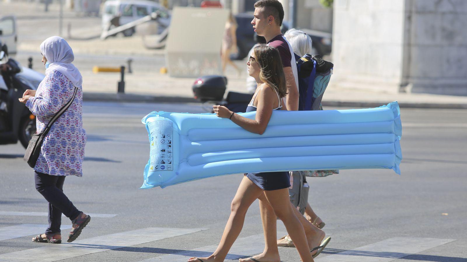 Una joven camina con una colchoneta bajo el brazo en Málaga.