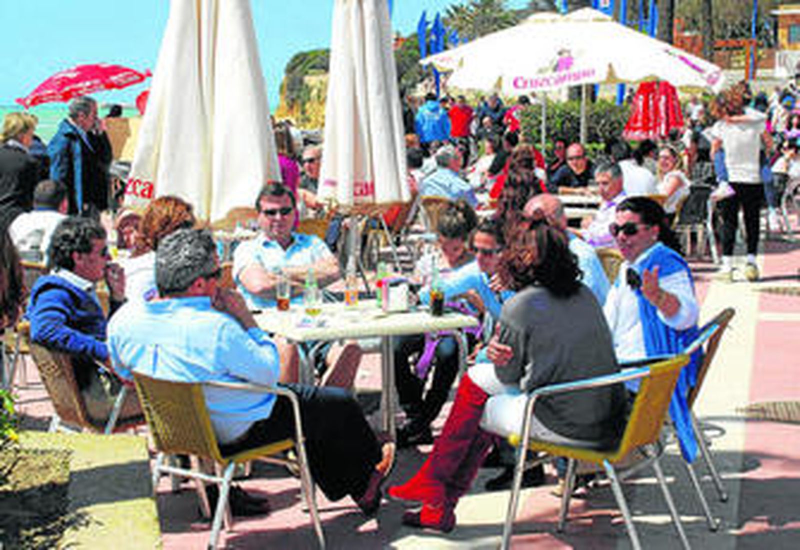 Clientes en una terraza de los bares situados en la primera pista de La Barrosa.