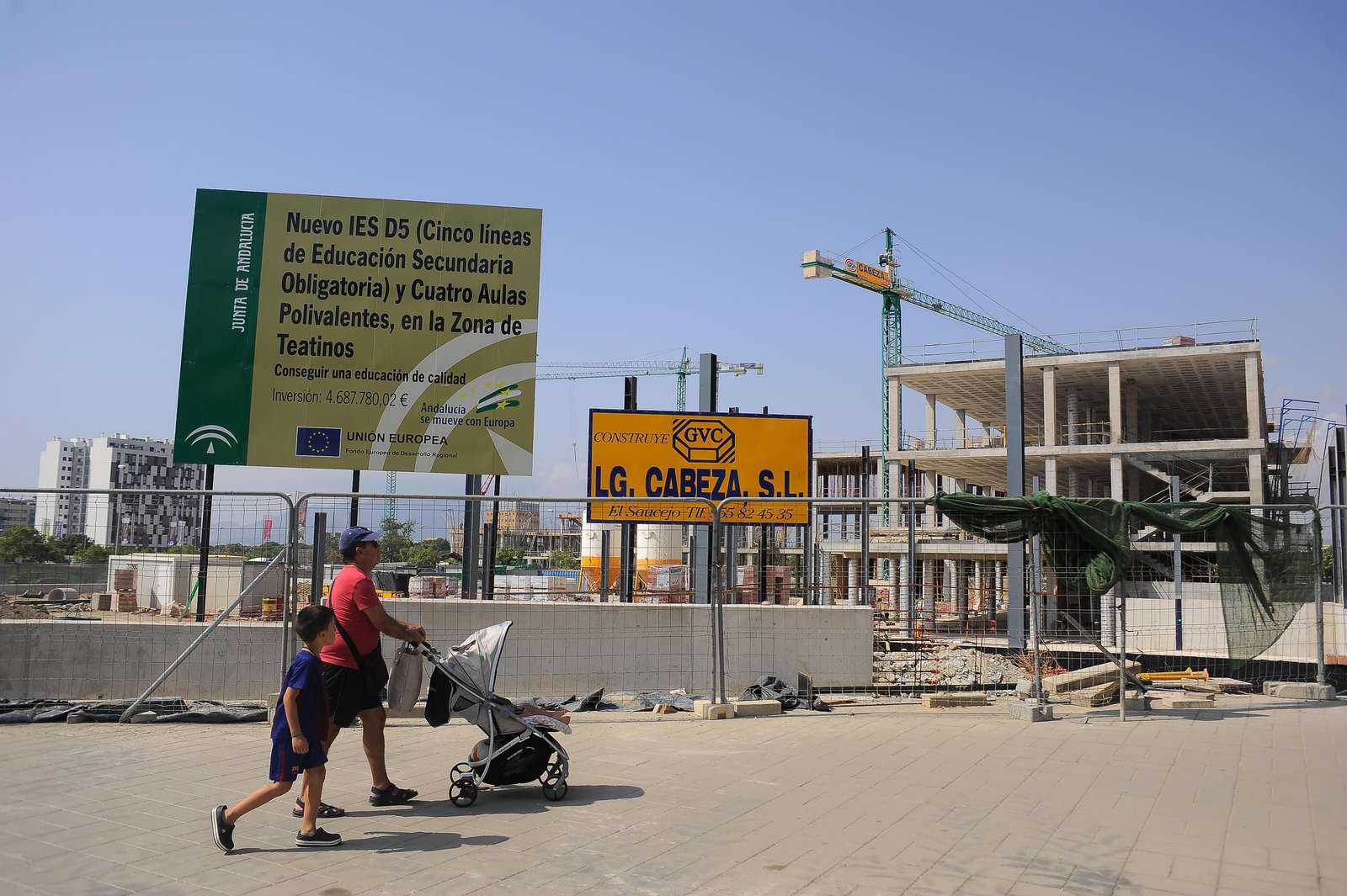 Un padre pasea con sus hijos junto a la obra del nuevo instituto de Teatinos.
