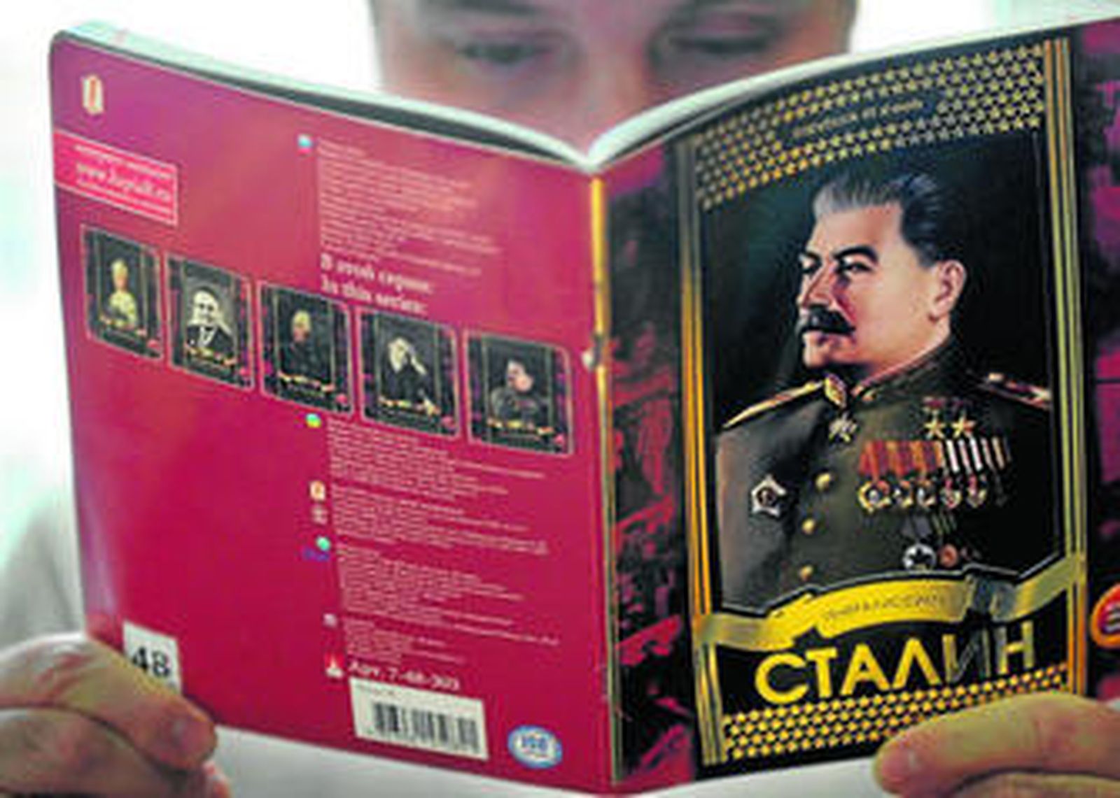 Un hombre lee un ejemplar del cuaderno en el que se ensalza a Stalin.