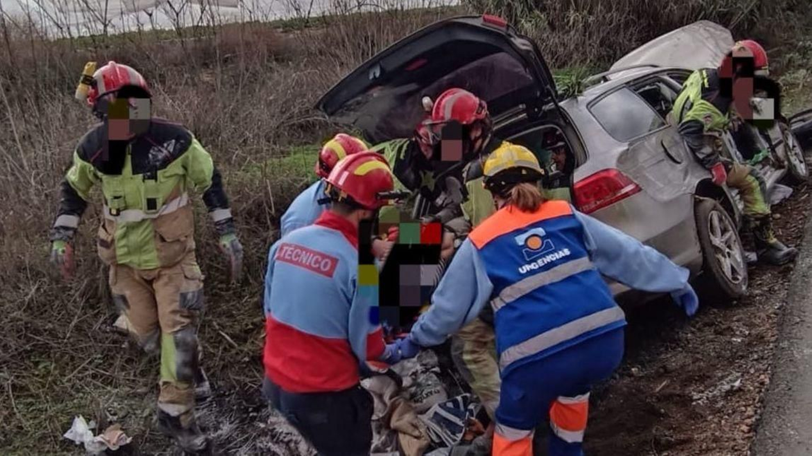 Sanitarios y bomberos rescatando a la mujer que había quedado atrapada en el vehículo.