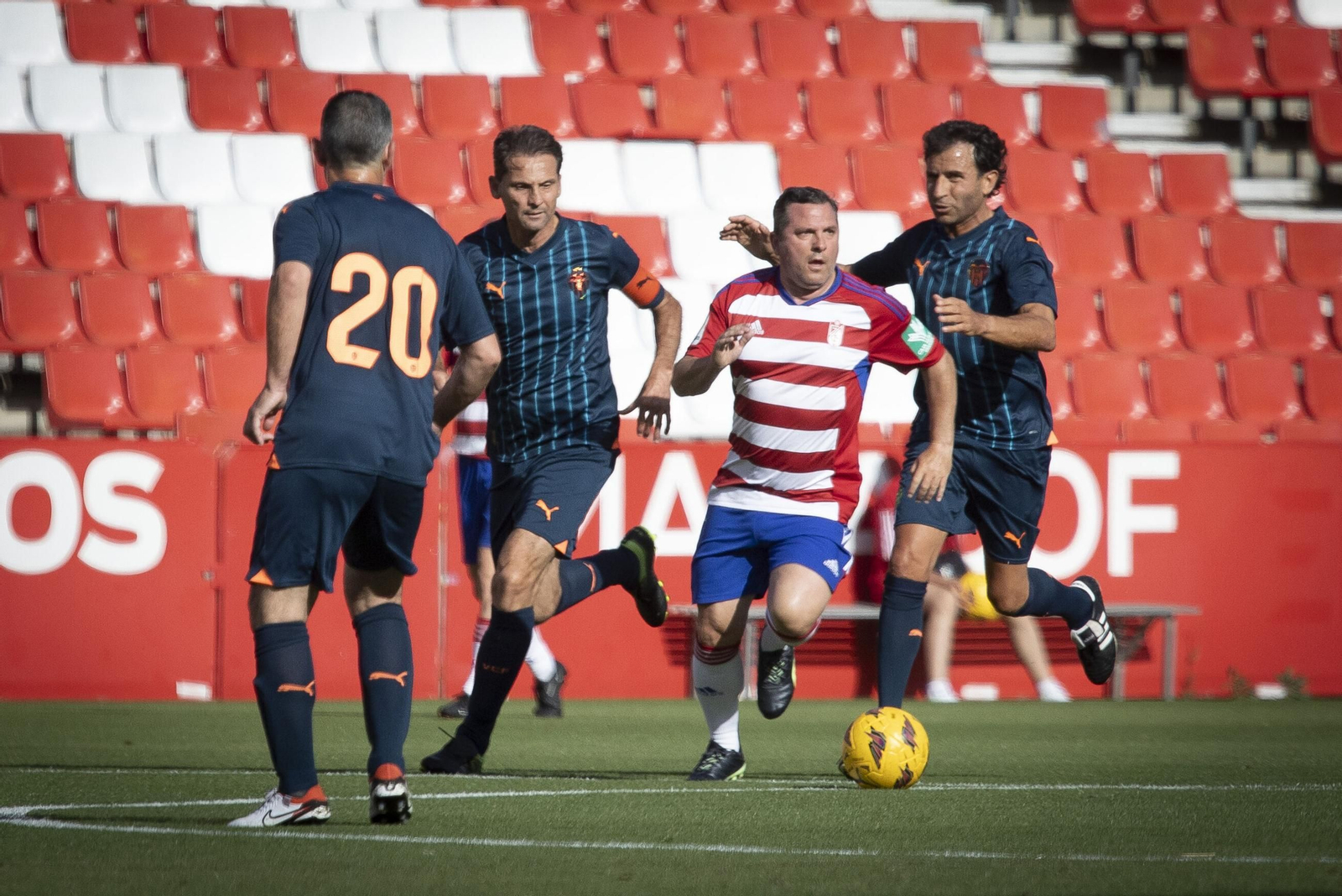 Un jugador conduce el balón ante la presión rival durantee un encuentro de veteranos entre el Granada y el Valencia.