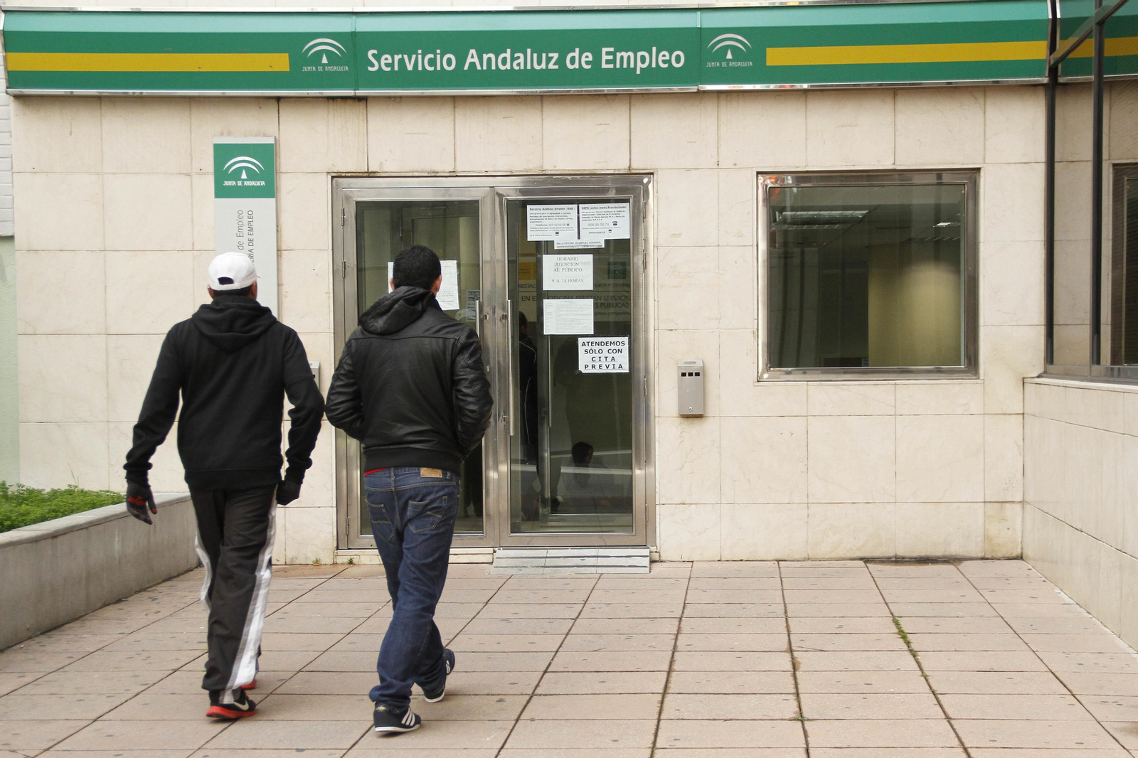 Dos desempleados, a la entrada de una oficina del SAE.