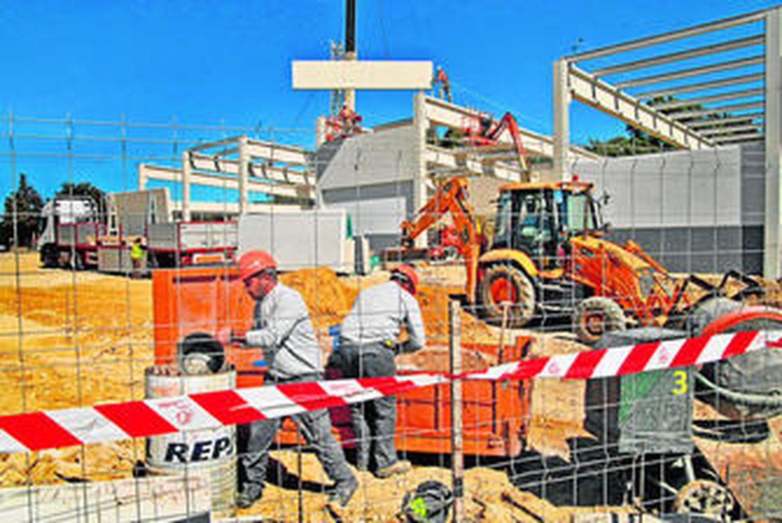 Trabajadores en plena faena frente a la nave del nuevo centro comercial de la cadena alemana.