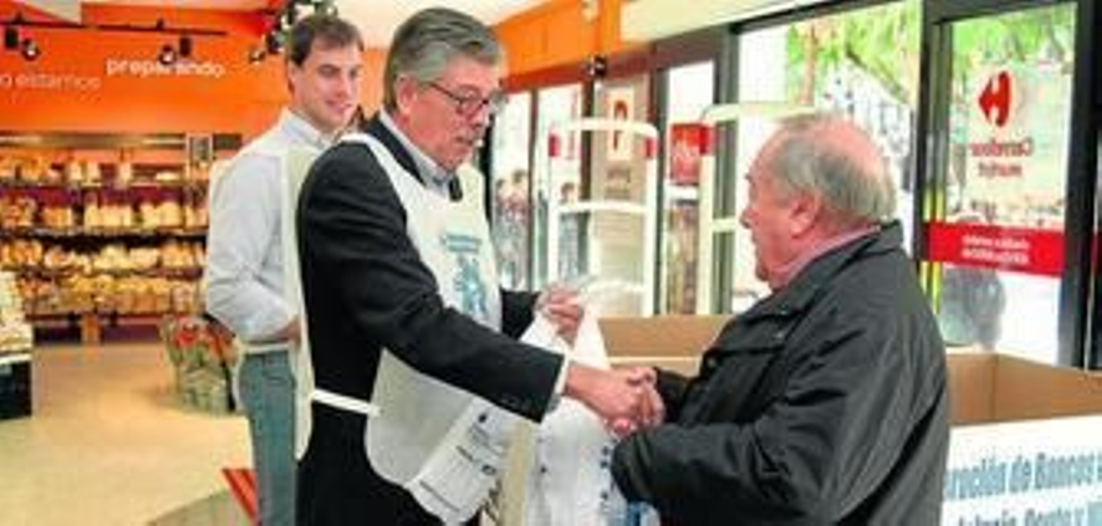 Varios voluntarios recogen la aportación de un onubense, en uno de los centros que participan en la campaña.