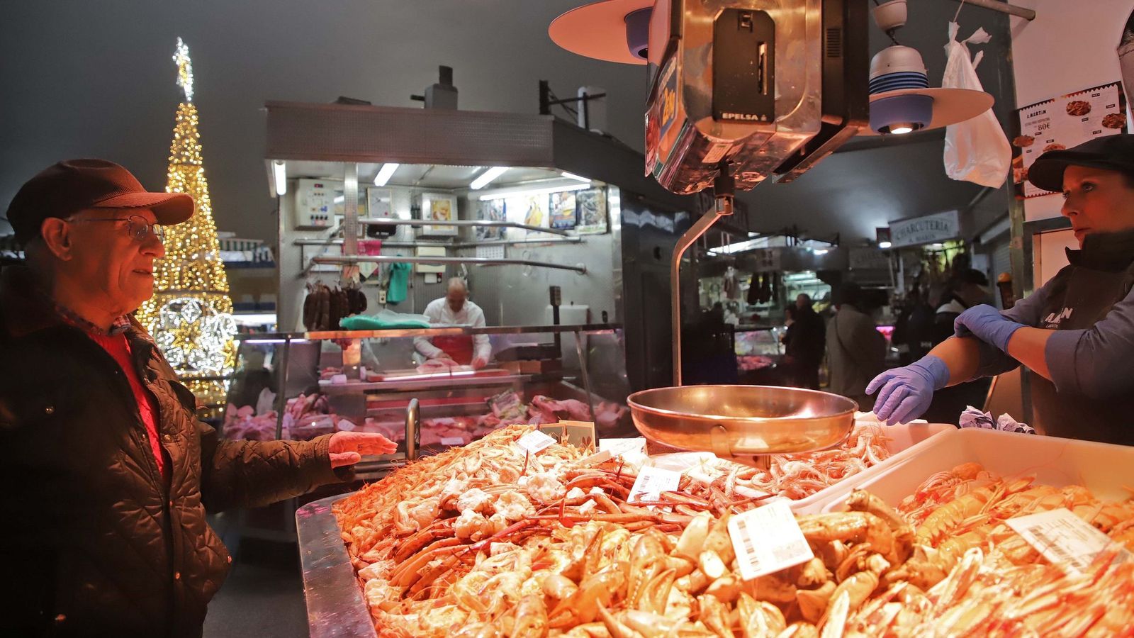 El mercado municipal Ingeniero Torroja–Sánchez Arcas luce este 24 de diciembre como ningún otro día del año. Bajo la gran claraboya, el árbol de Navidad preside un alboroto alegre y contagioso.