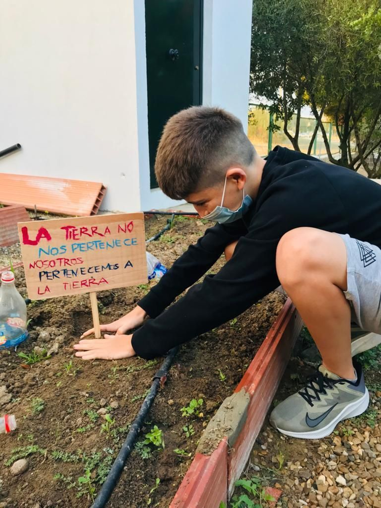 Un alumno del IES Antonio Muro coloca uno de los carteles en el huerto escolar