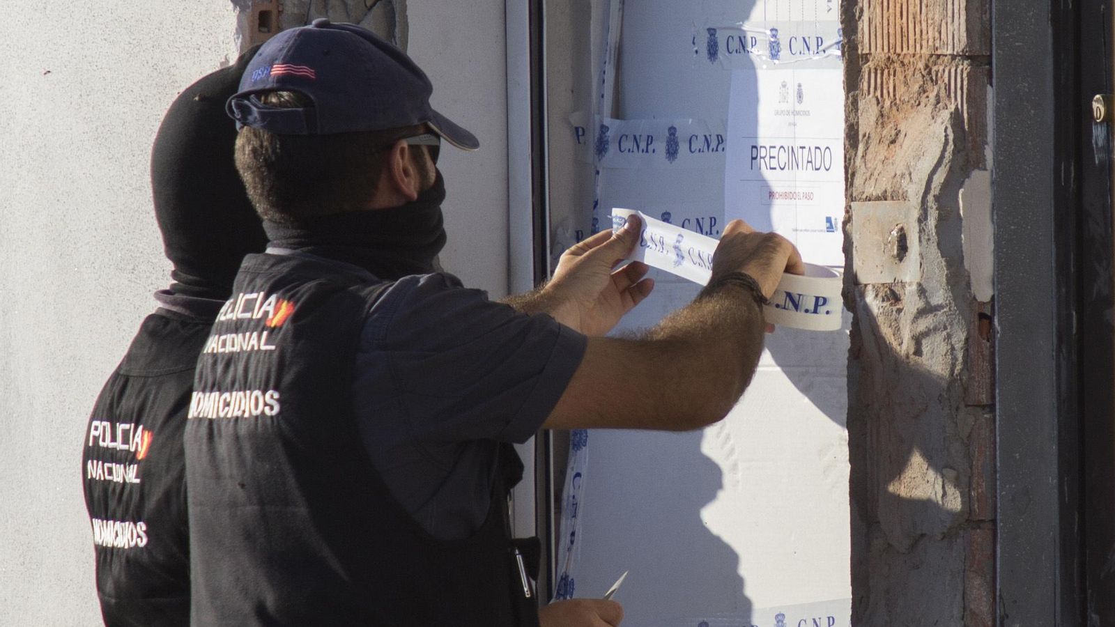 Policías colocando precintos en la ventana