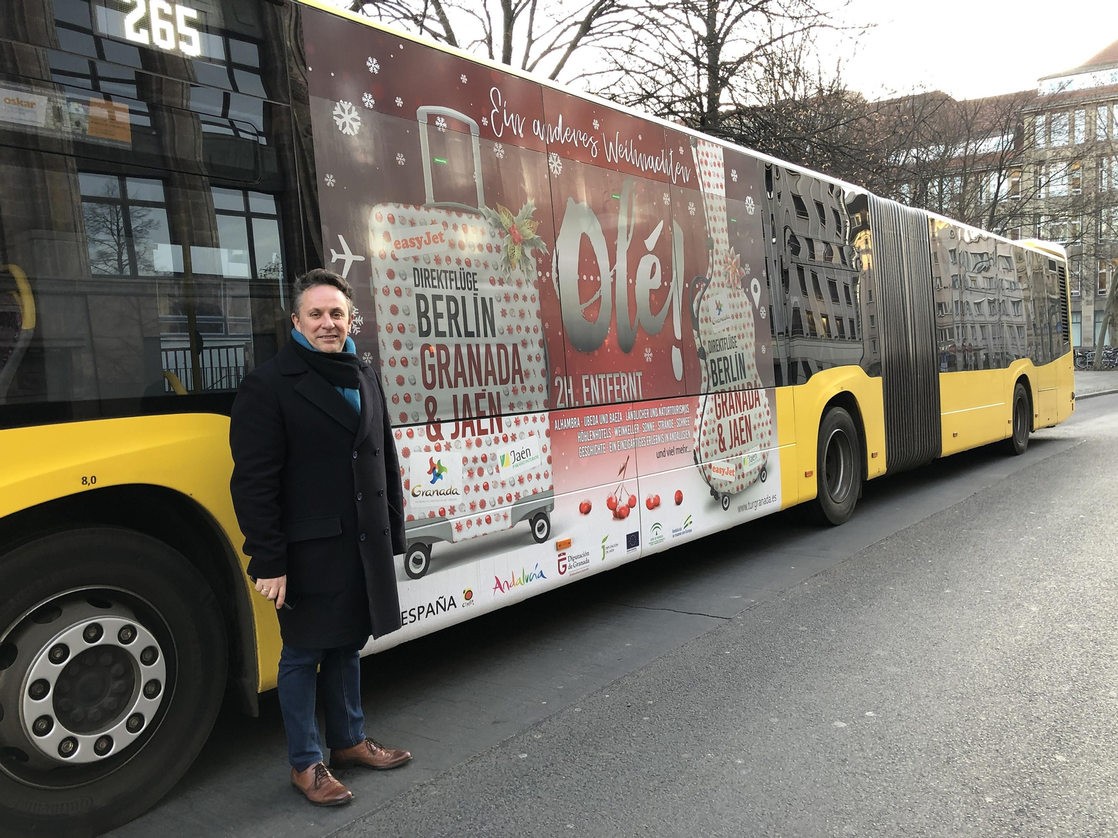 El diputado de Turismo, Enrique Medina, junto a uno de los autobuses que promociona la ruta Granada-Berlín en Alemania